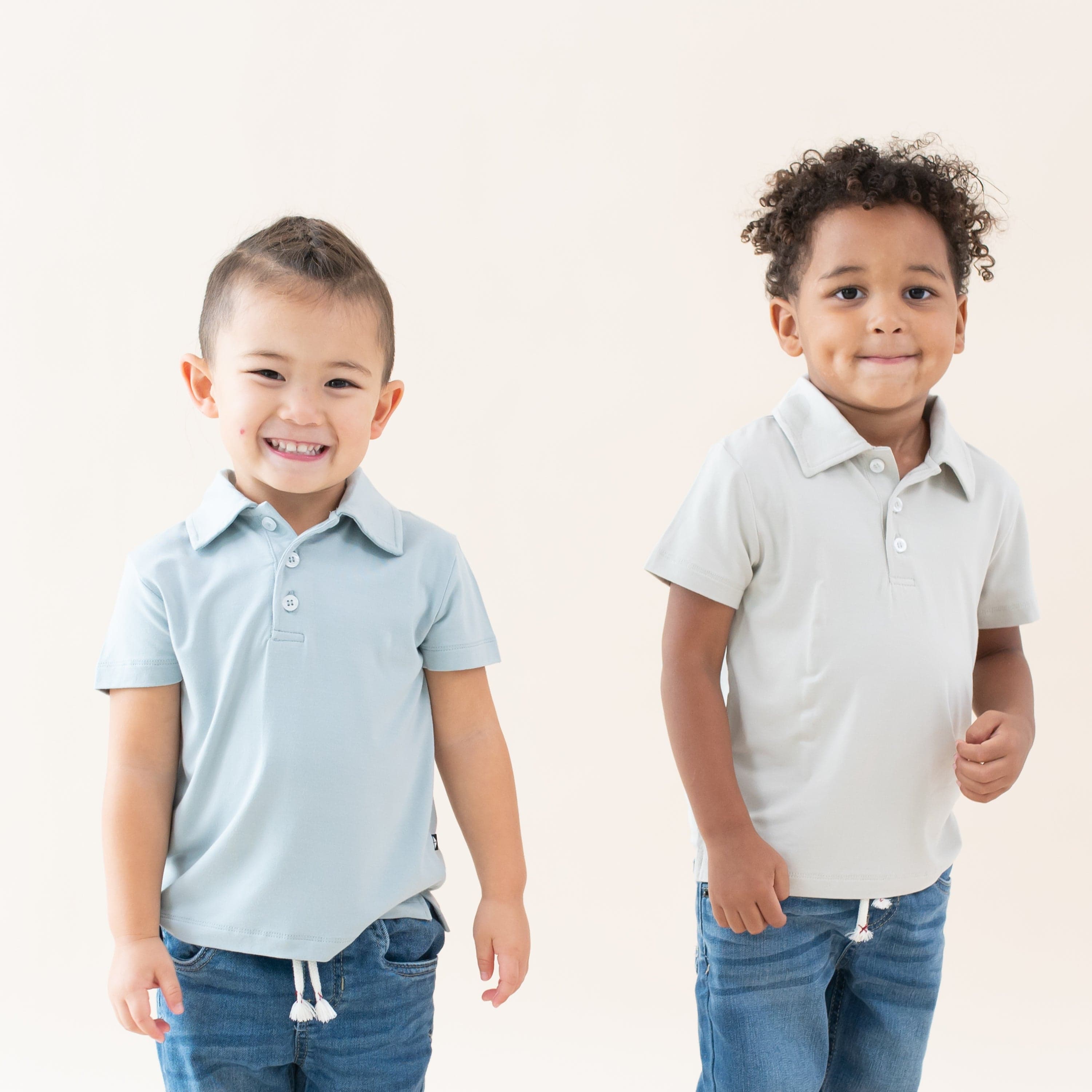 Toddlers wearing Kyte Baby Bamboo Short Sleeve Polos in Fog and Oat