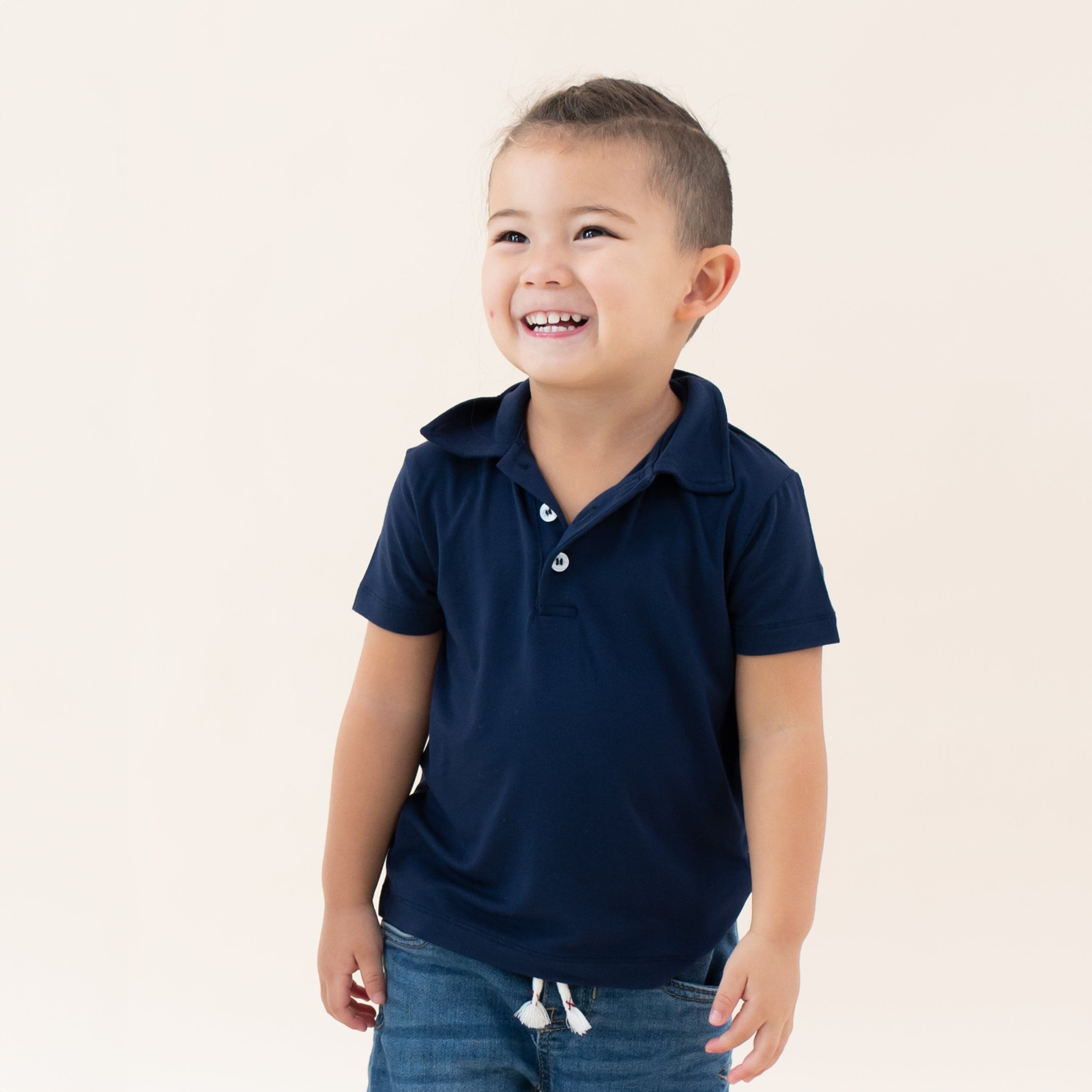 Toddler wearing Kyte Baby Short Sleeve Polo in Navy