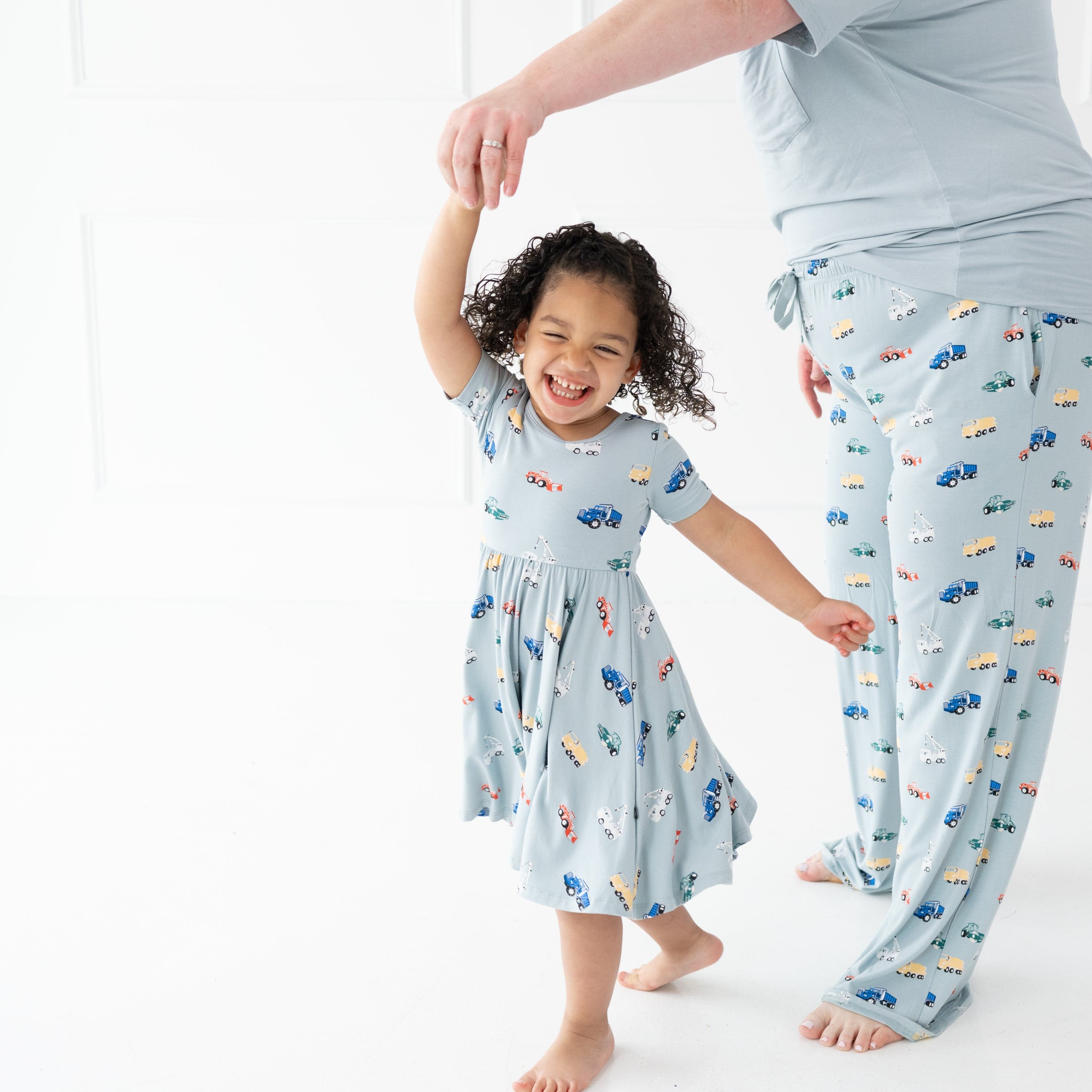 Girl wearing the Twirl Dress in Construction being twirled