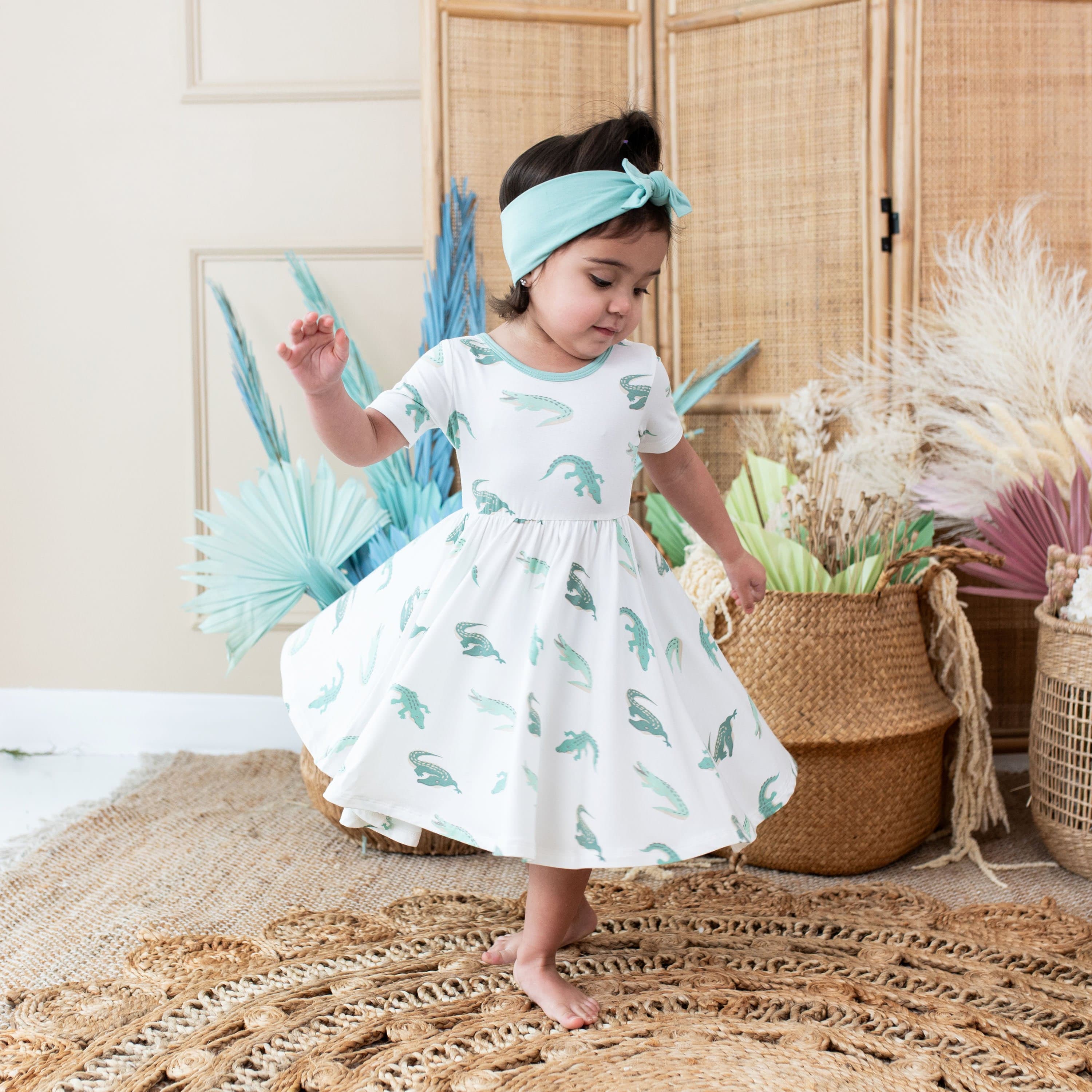 Toddler dancing in Kyte Baby Twirl Dress in Crocodile