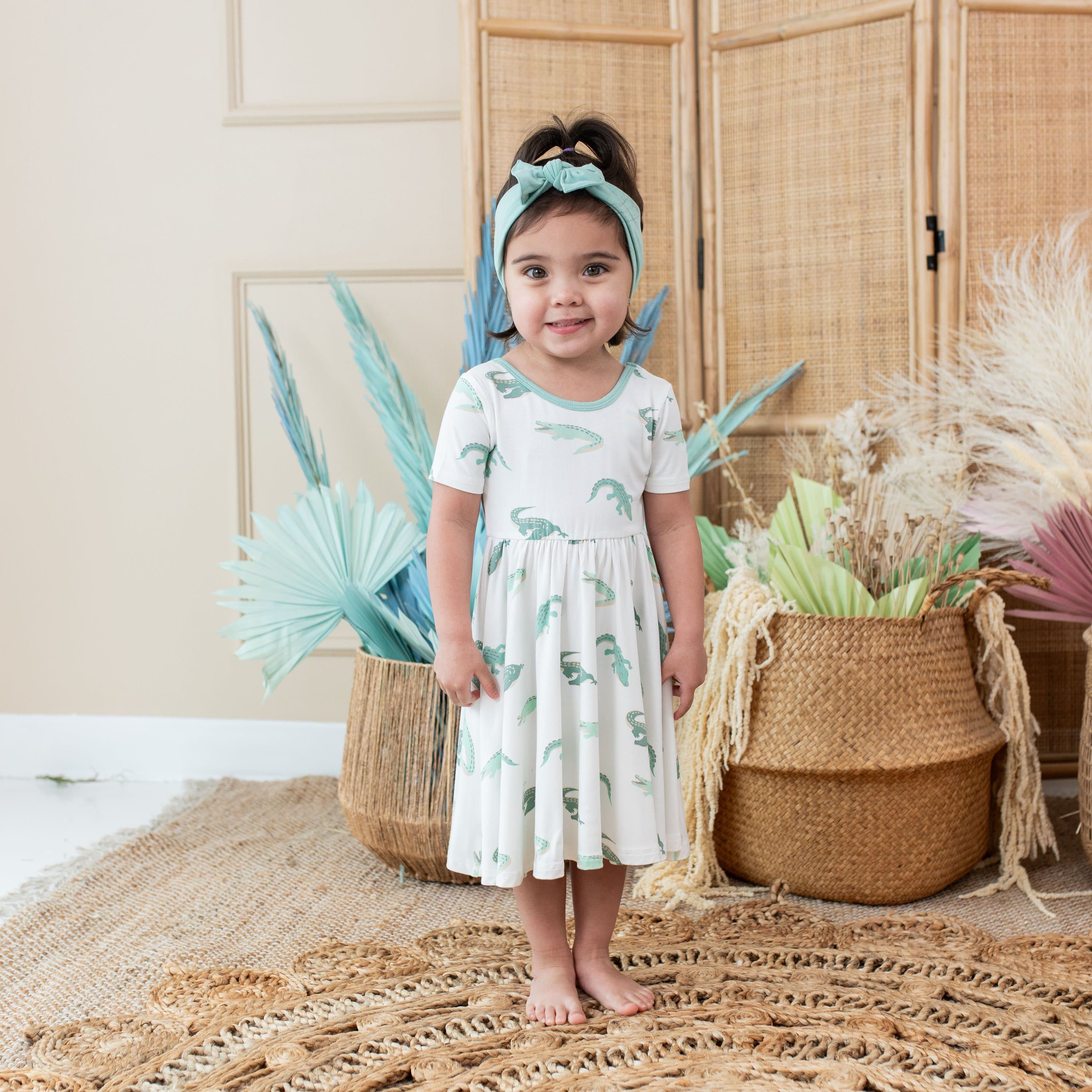 Girl wearing Kyte Baby Twirl Dress in Crocodile