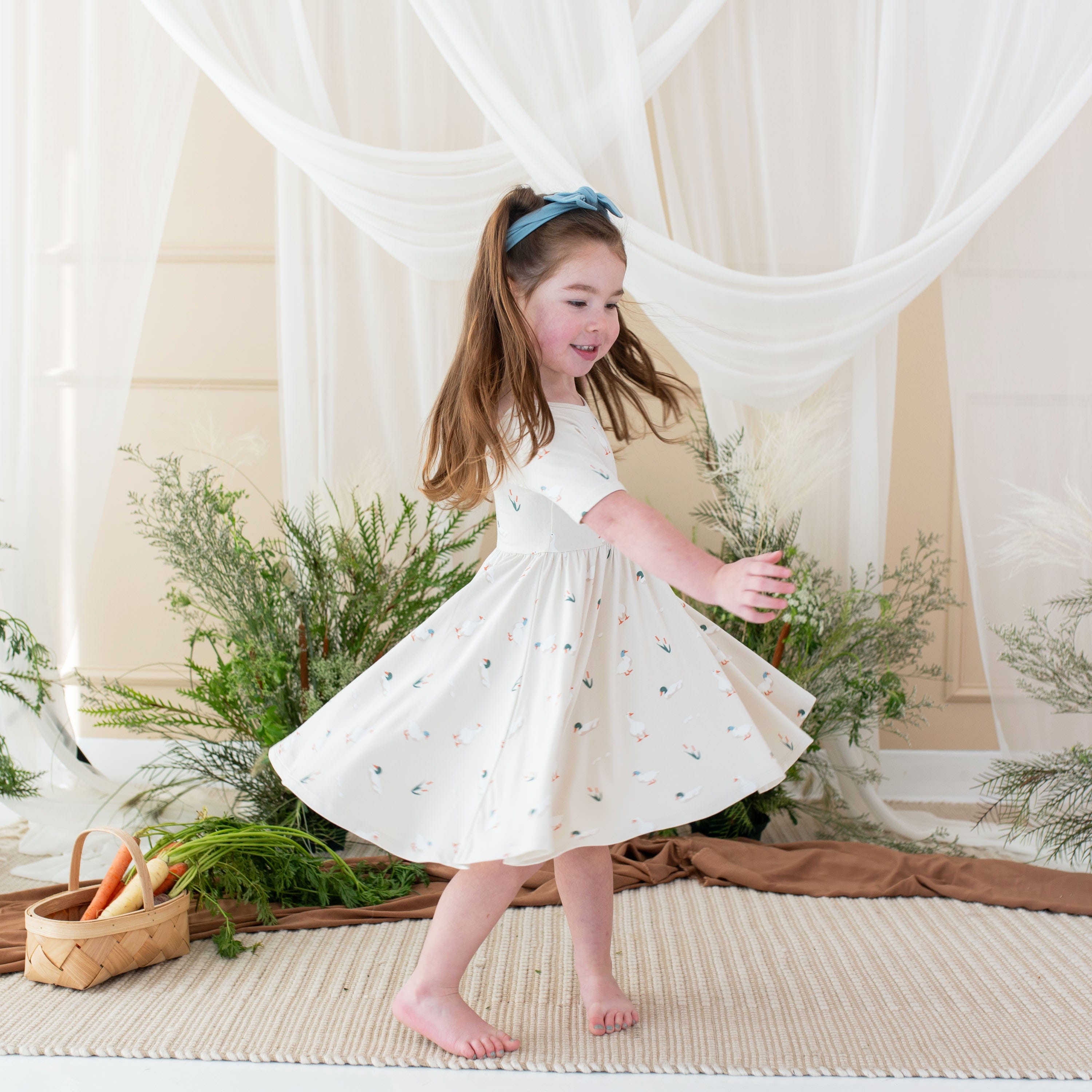 Girl wearing Kyte Baby Twirl Dress in Duck