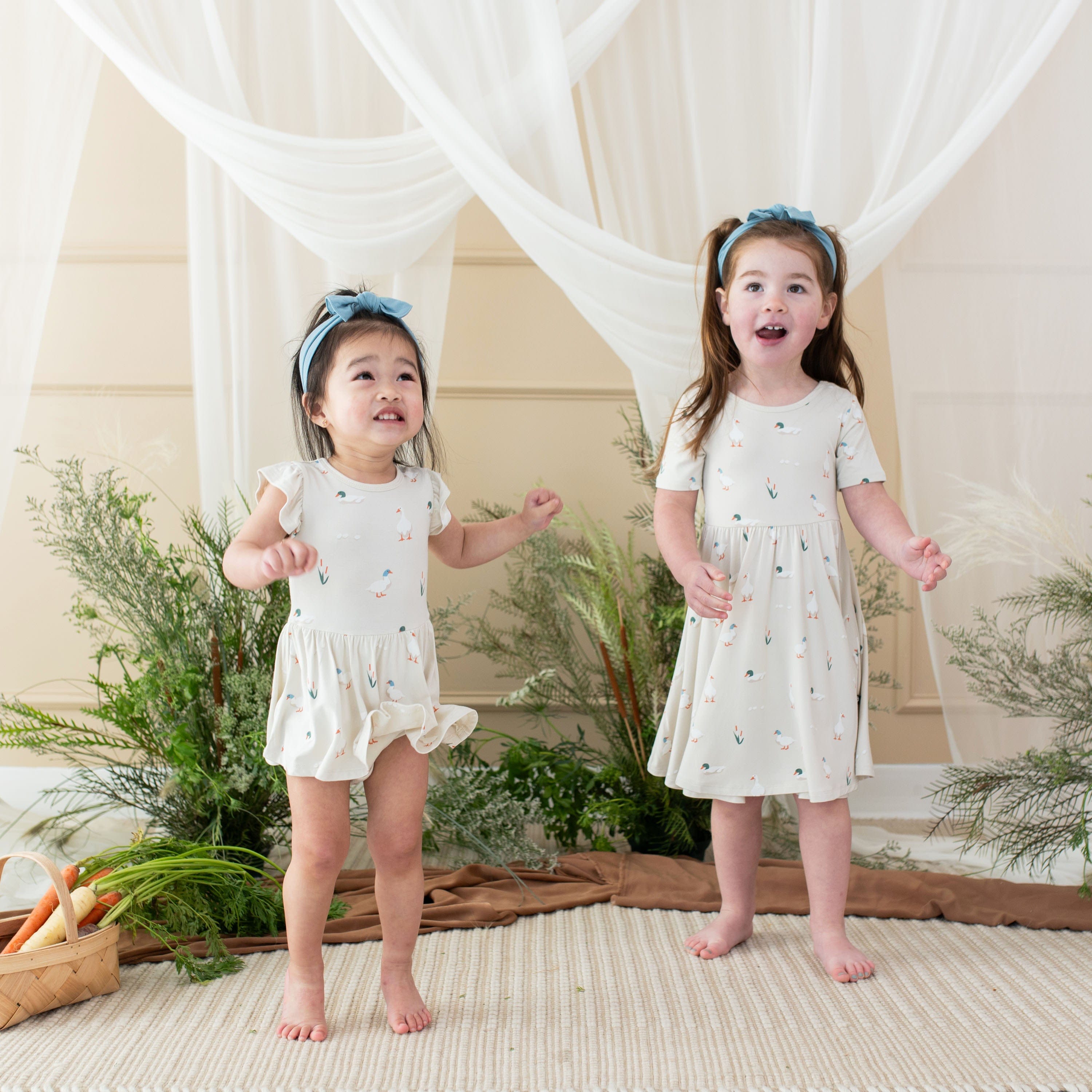 Children wearing matching Kyte Baby Twirl Dresses in Duck
