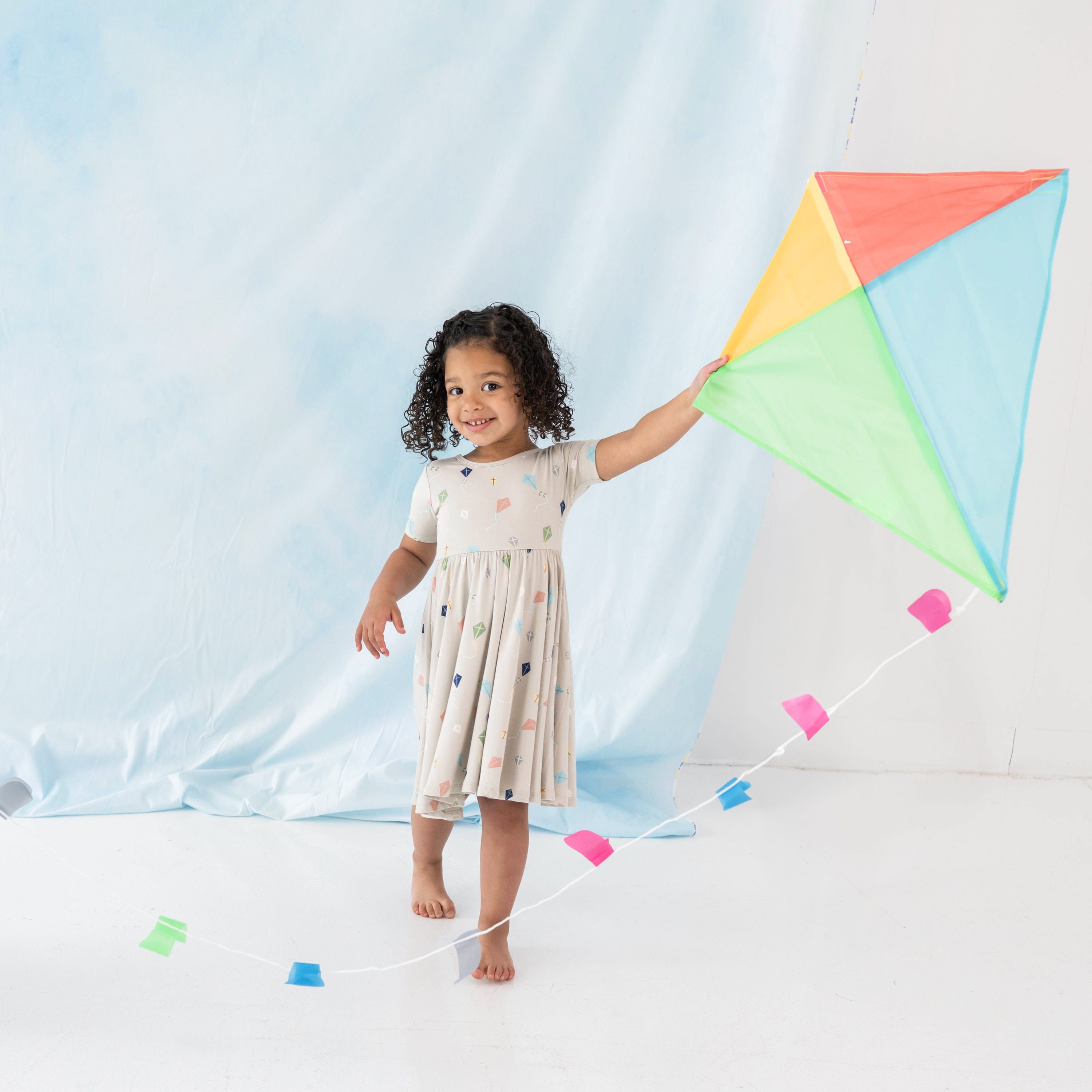 Toddler wearing Kyte Baby Twirl Dress in Kite