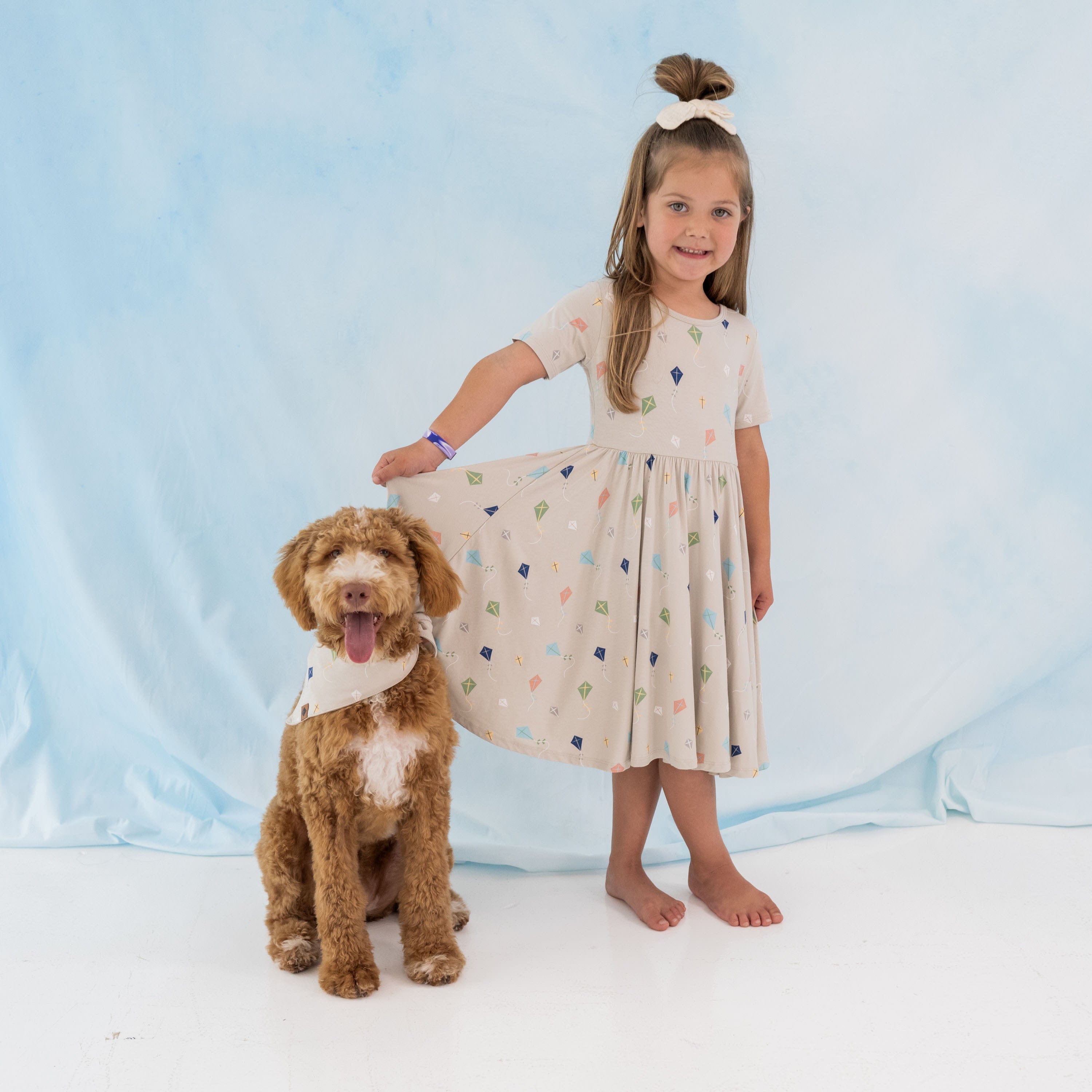 Girl wearing Kyte Baby Short Sleeve Twirl Dress with ballerina neckline in Kite