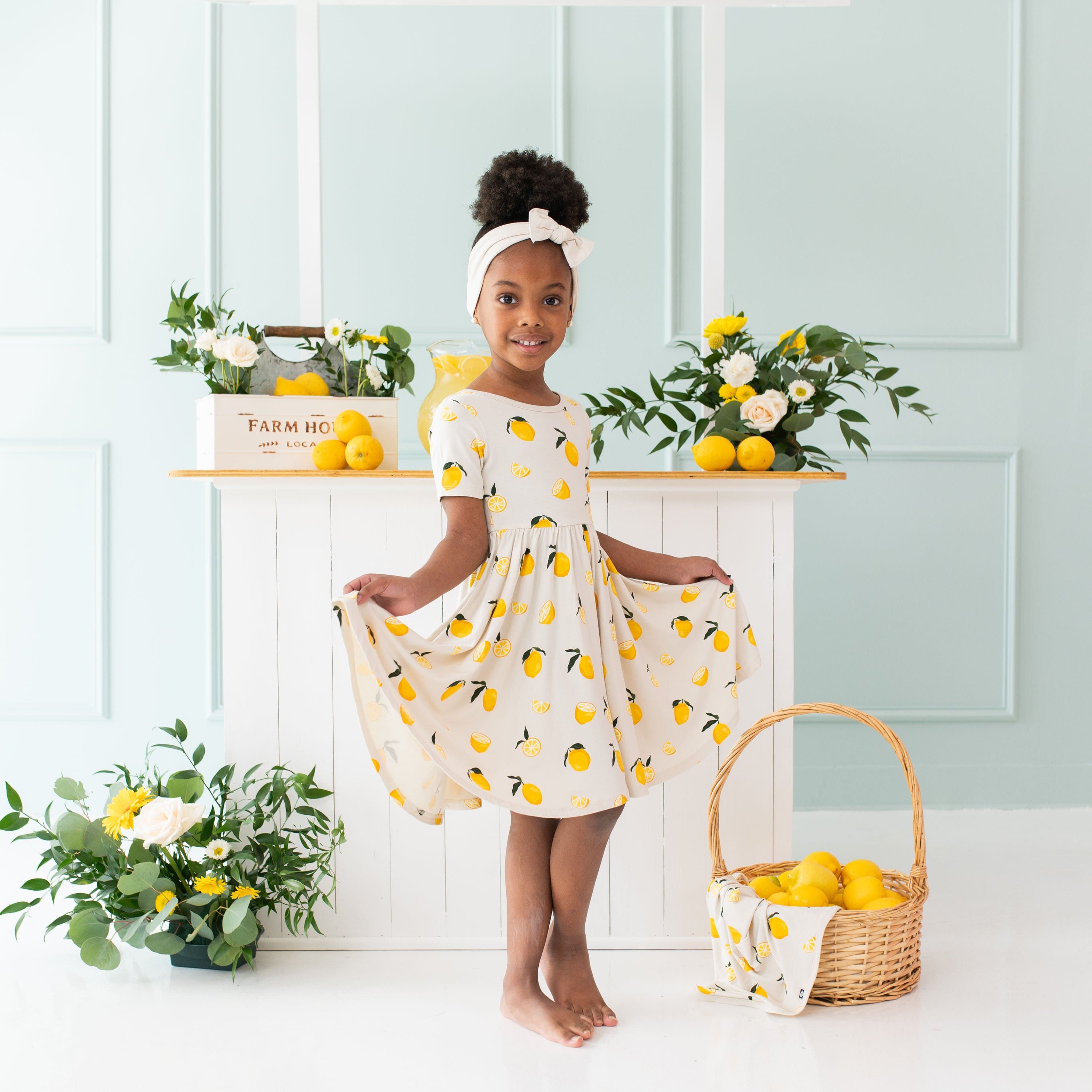 Girl wearing Kyte Baby Twirl Dress in Lemon