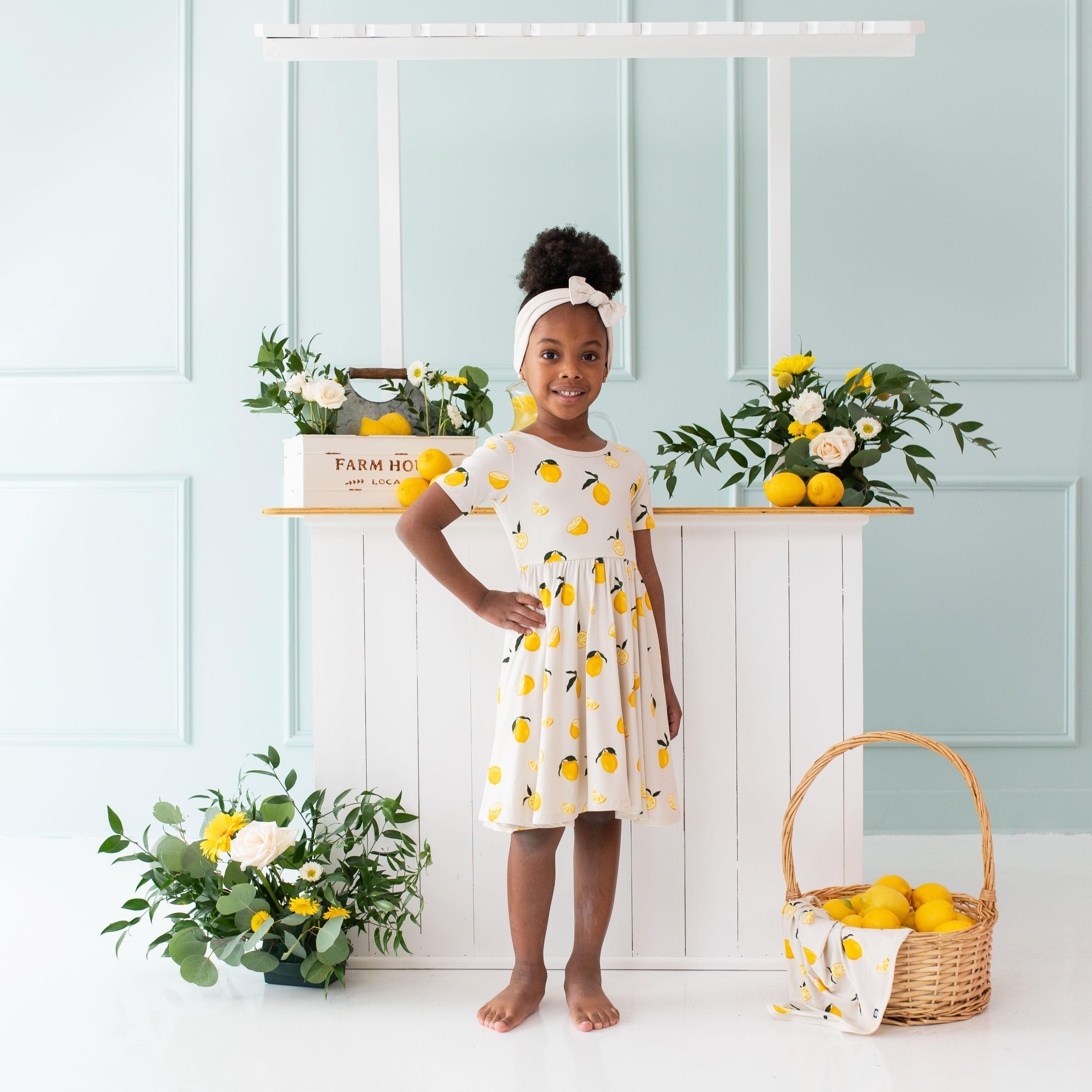 Girl wearing Kyte Baby Short Sleeve Twirl Dress in Lemon