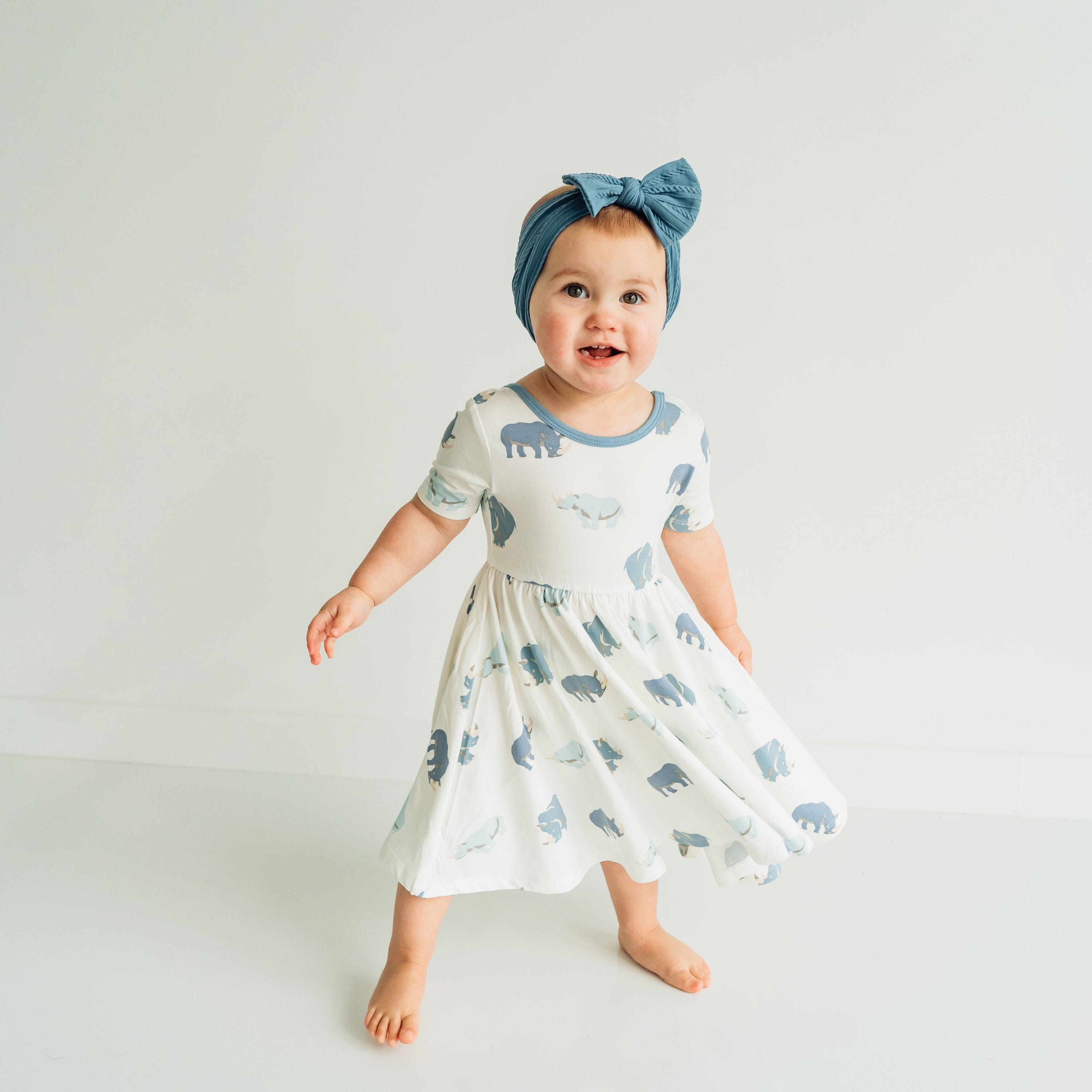 Girl wearing Kyte Baby Twirl Dress in Rhino