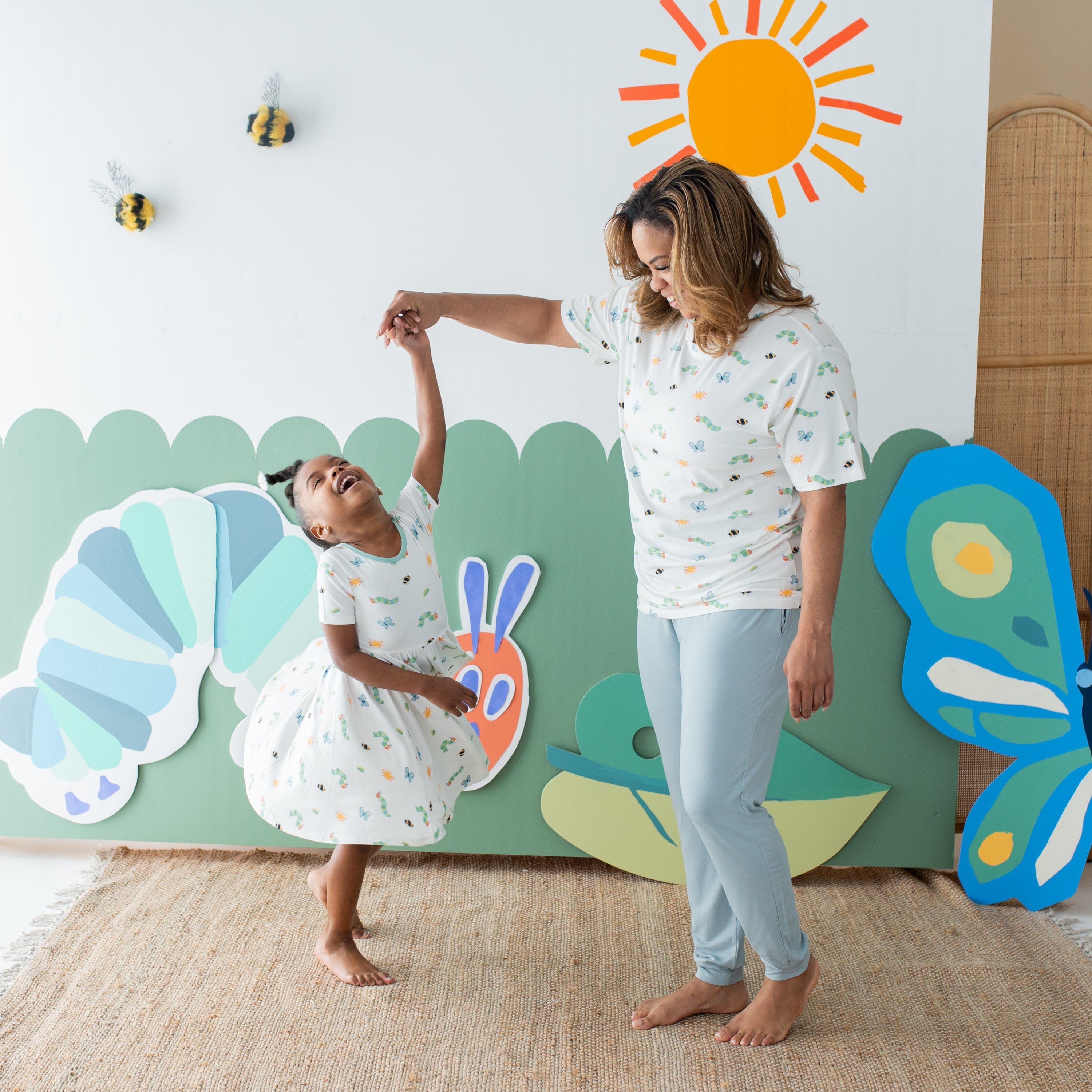 Mom twirling daughter wearing Kyte Baby Bamboo Twirl Dress in The Very Hungry Caterpillar™ and Friends