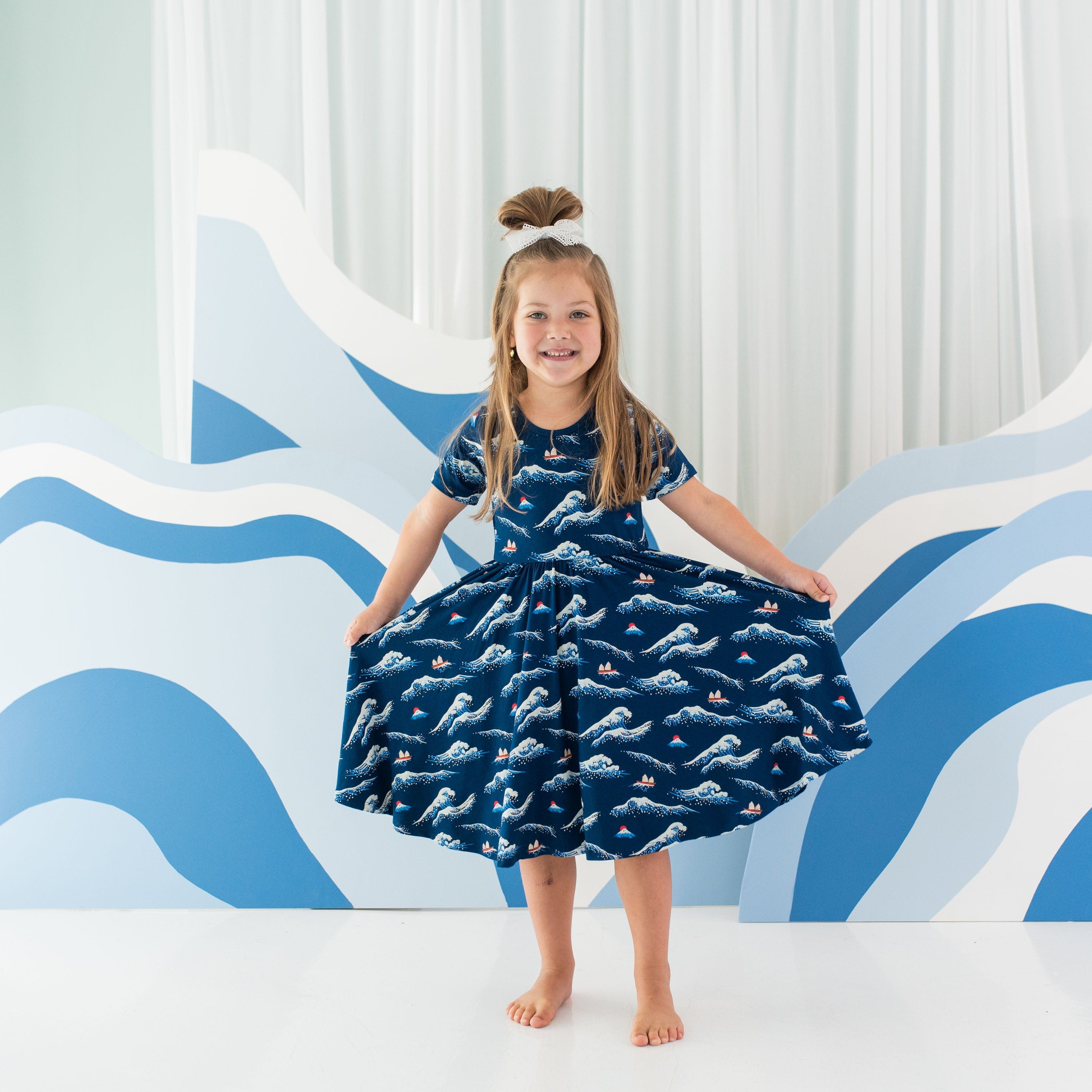 Girl wearing Kyte Baby Twirl Dress in Wave