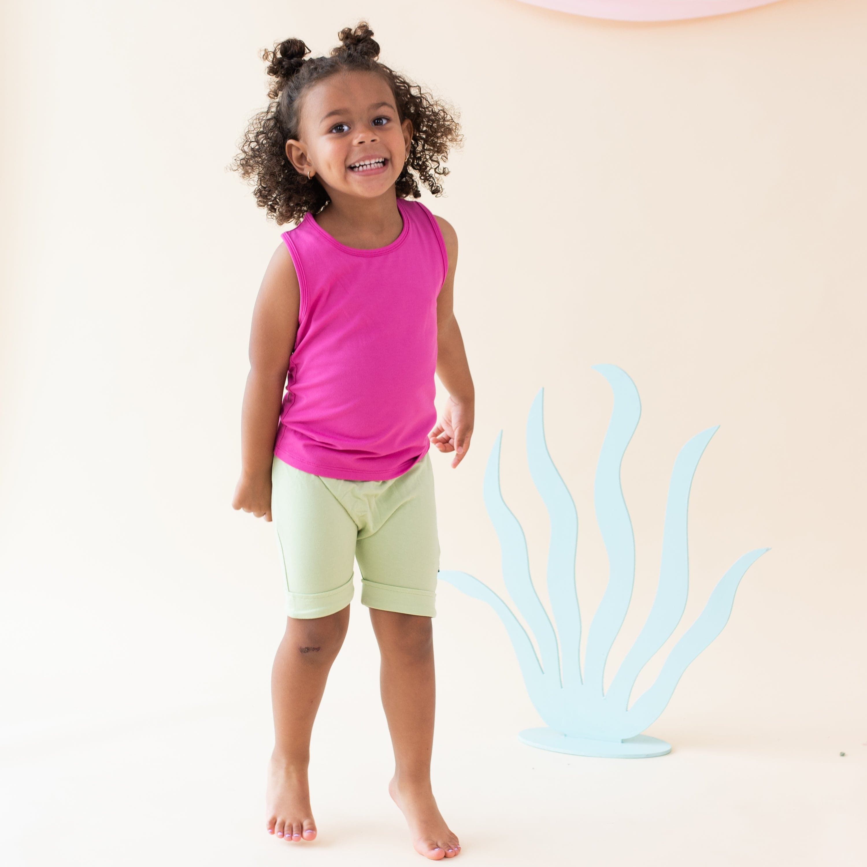 Toddler wearing Kyte Baby bamboo Tank Top in Raspberry pink