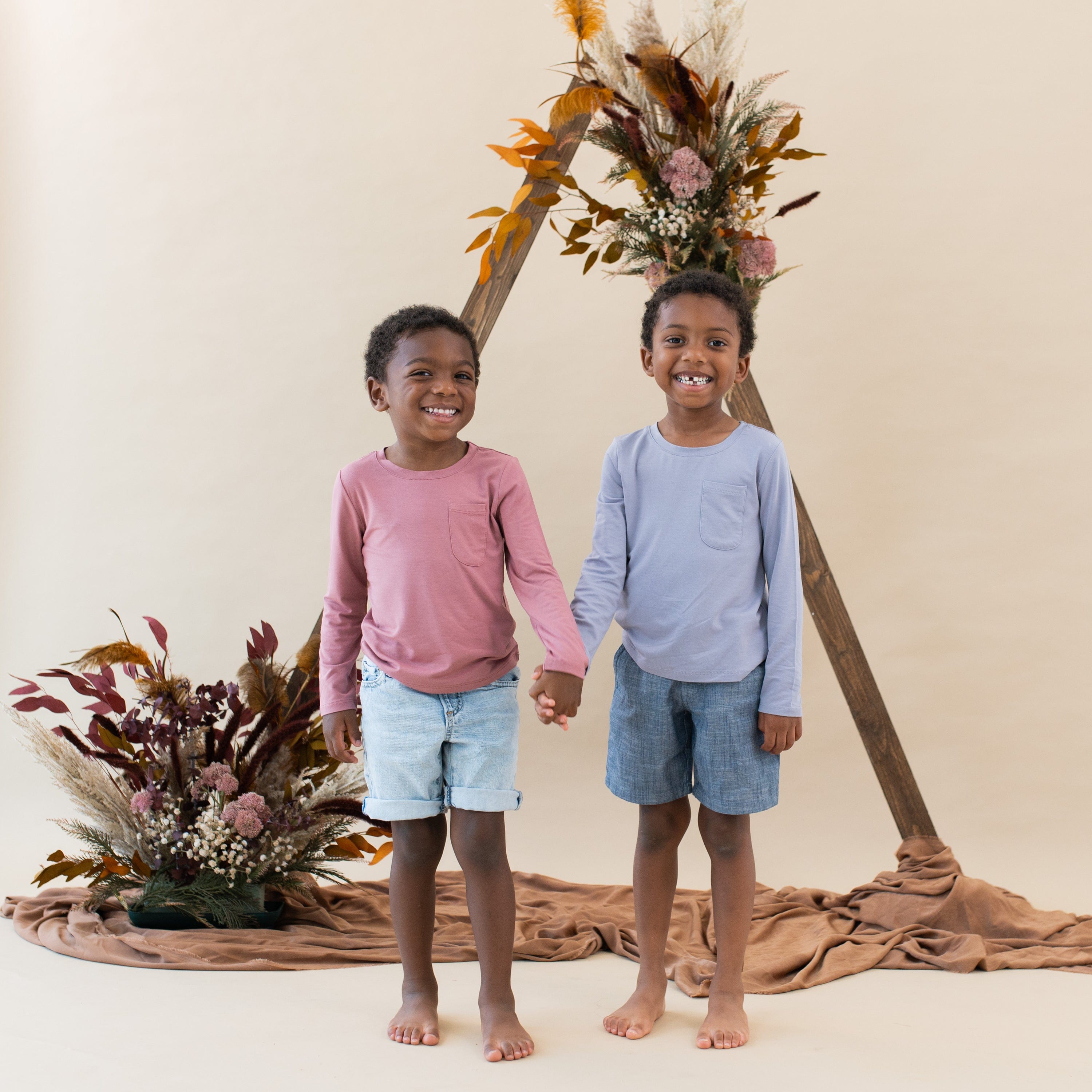 Toddlers wearing Kyte Baby Long Sleeve Crew Neck Tees with pockets
