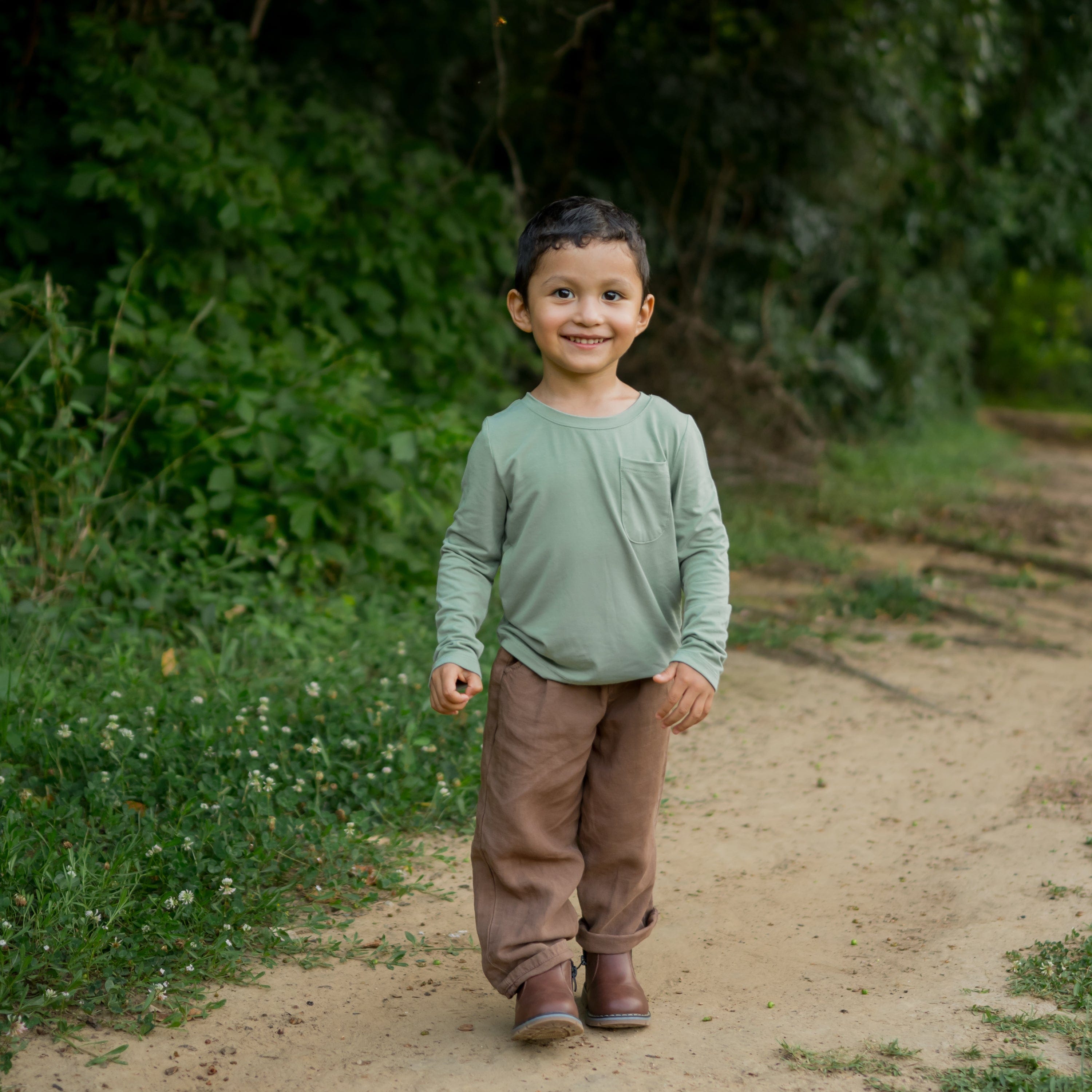 Toddler wearing Kyte Baby Unisex Long Sleeve Crew Neck Tee with pocket in Thyme green