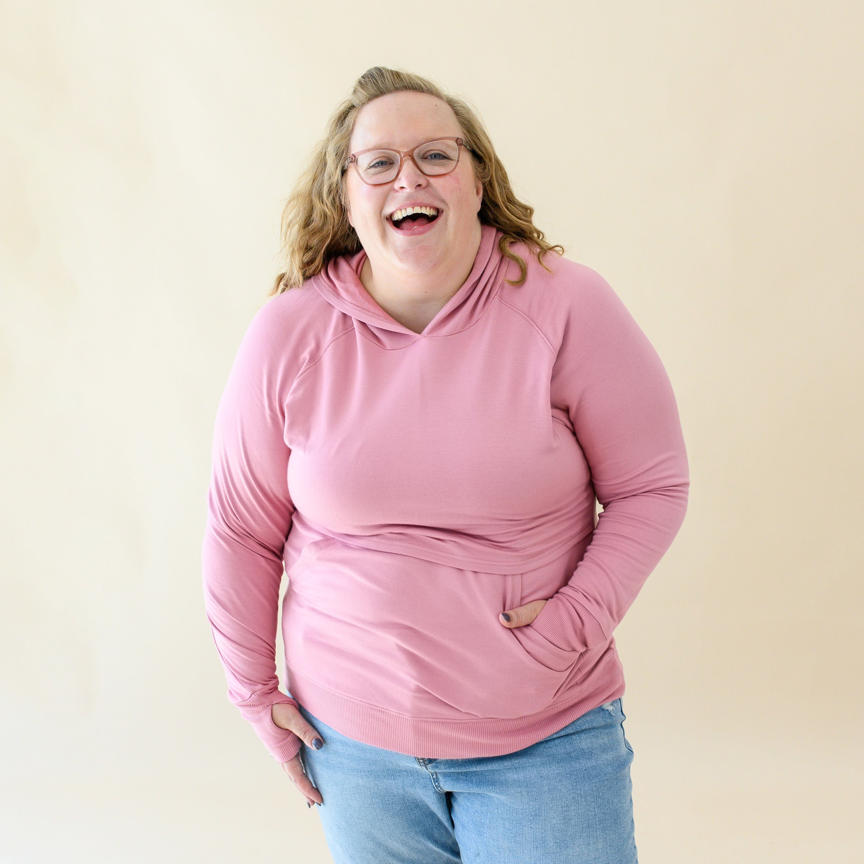 Woman wearing Kyte Baby Women's French Terry Nursing Hoodie in Apple Blossom Pink