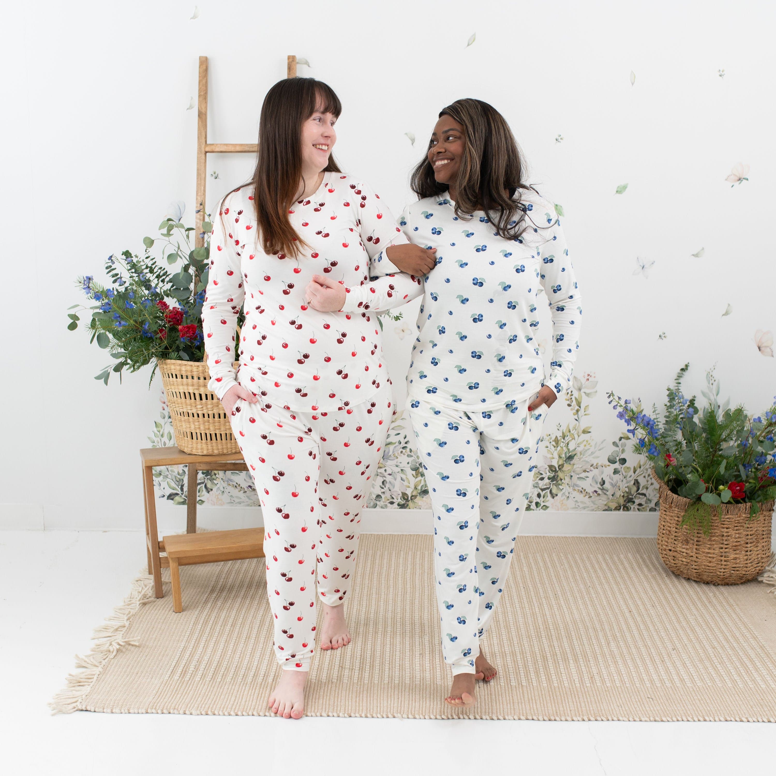 Women wearing Kyte Baby jogger pajamas in Cherry and Blueberry prints