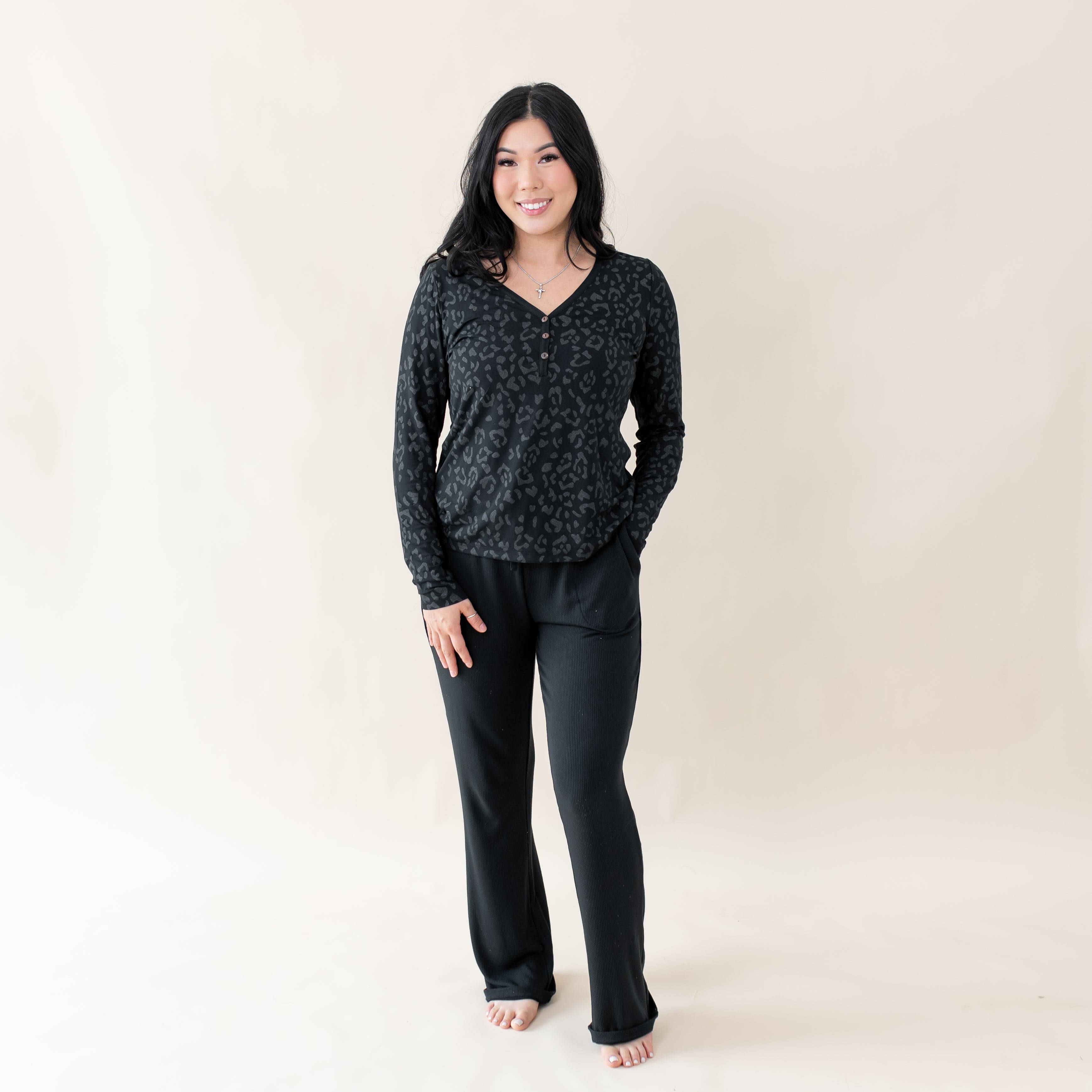 Woman wearing Kyte Baby Women's Breathable Long Sleeve Henley Tee in Midnight Leopard