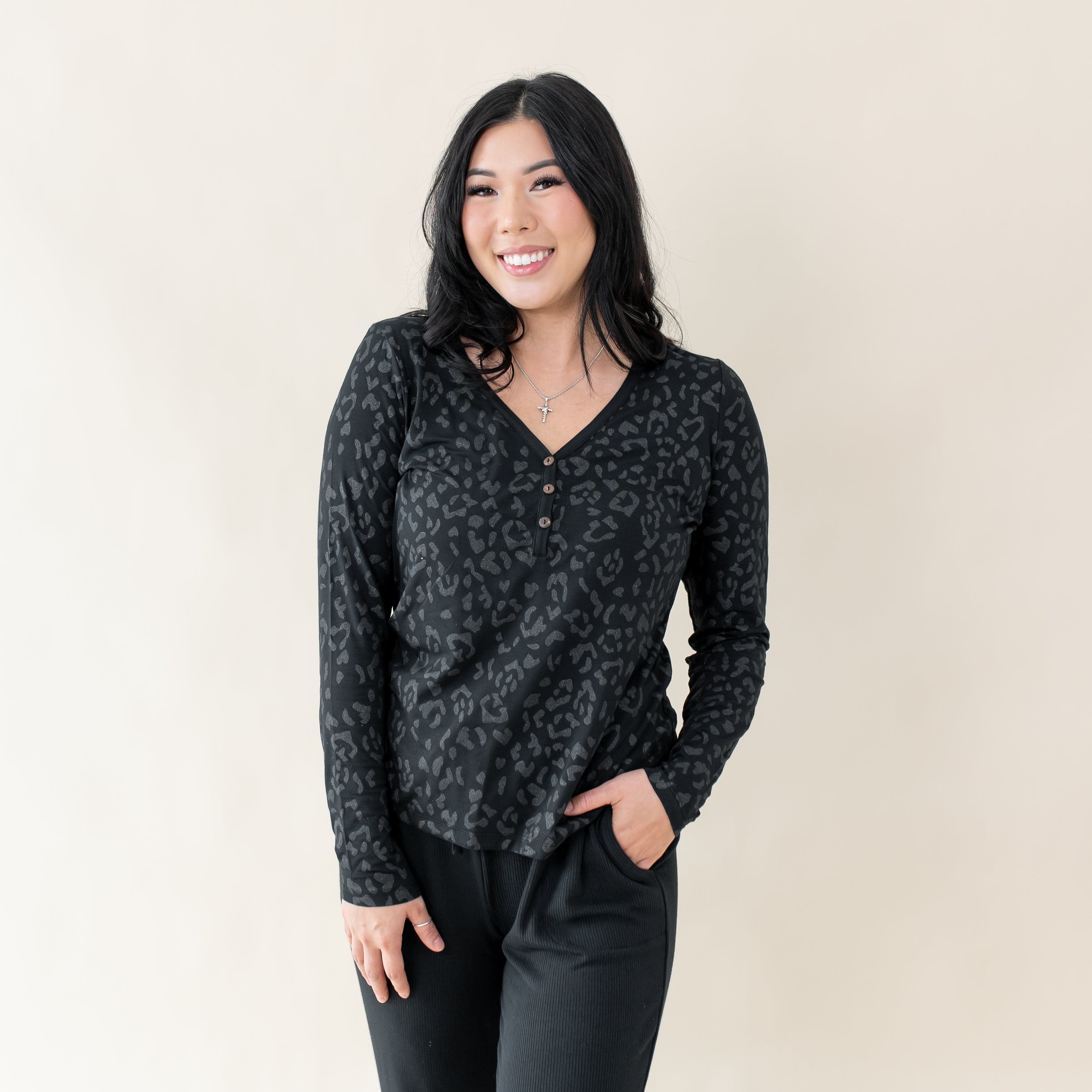 Woman wearing Kyte Baby Women's Long Sleeve Henley Tee in Midnight Leopard