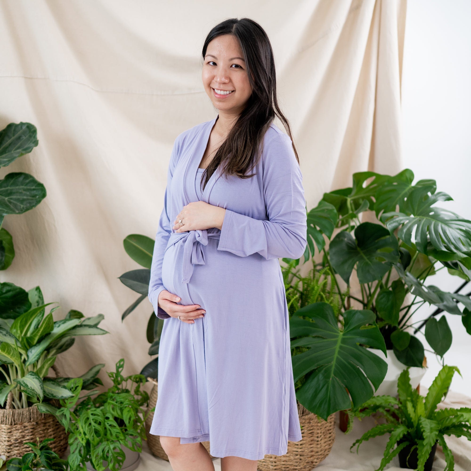 Woman wearing Kyte Baby Women’s Pregnancy Lounge Robe with 3/4 hem in Taro