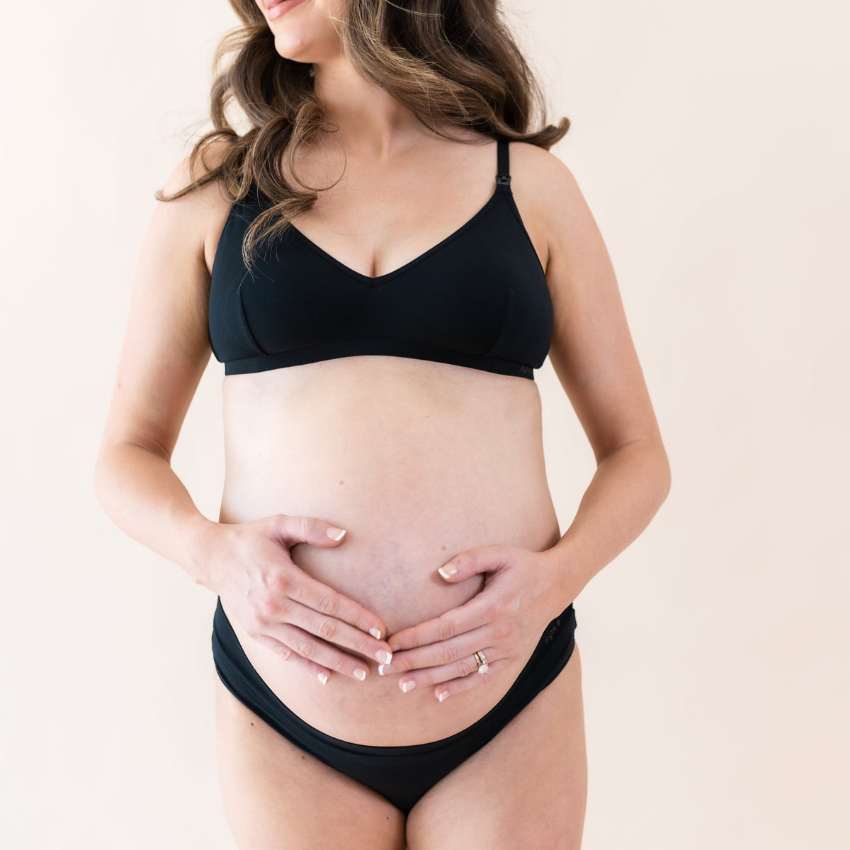 Pregnant woman wearing Kyte Baby Women's Nursing Bra in Midnight