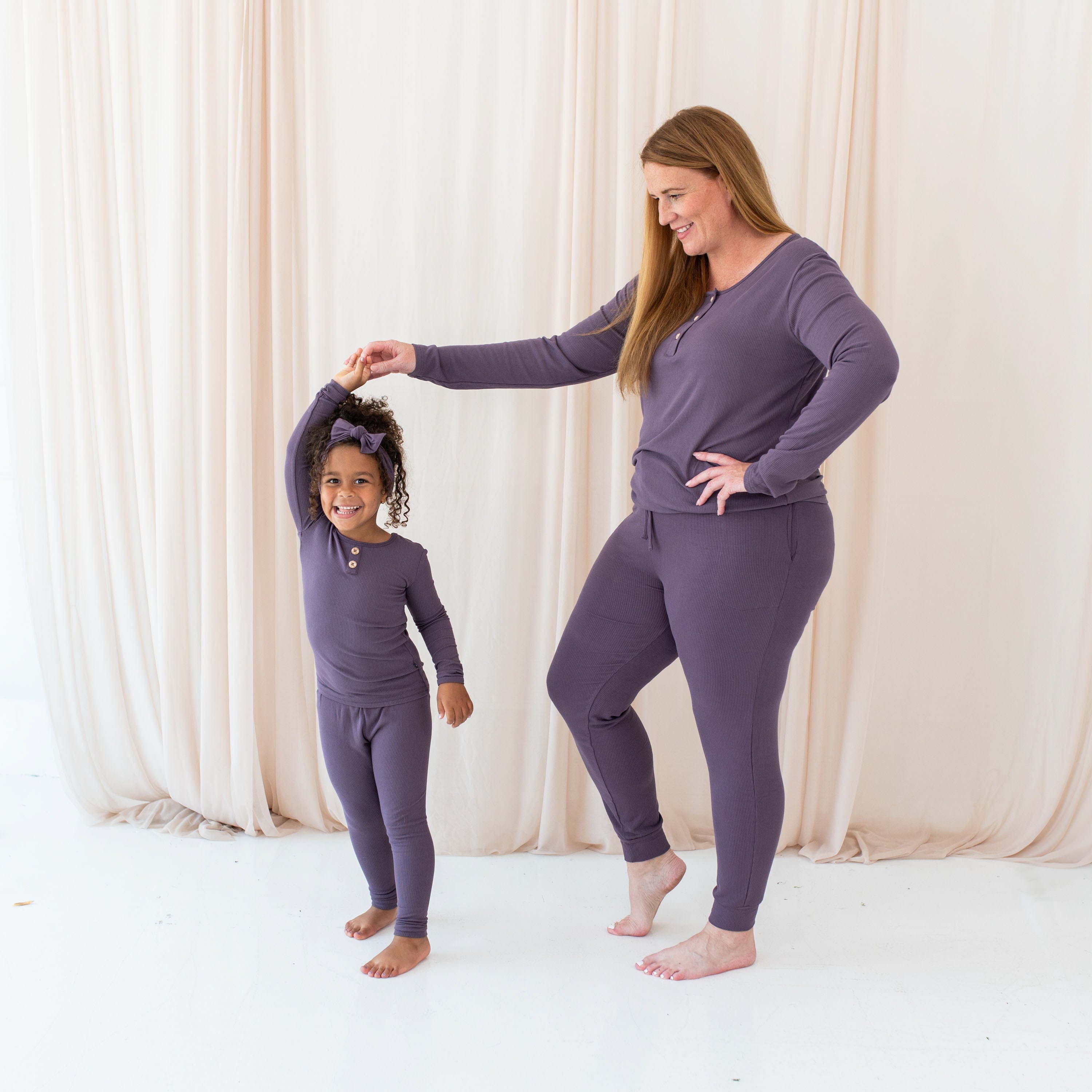 Mom and daughter wearing Kyte Baby Women's Ribbed Henley Top and Joggers in Currant