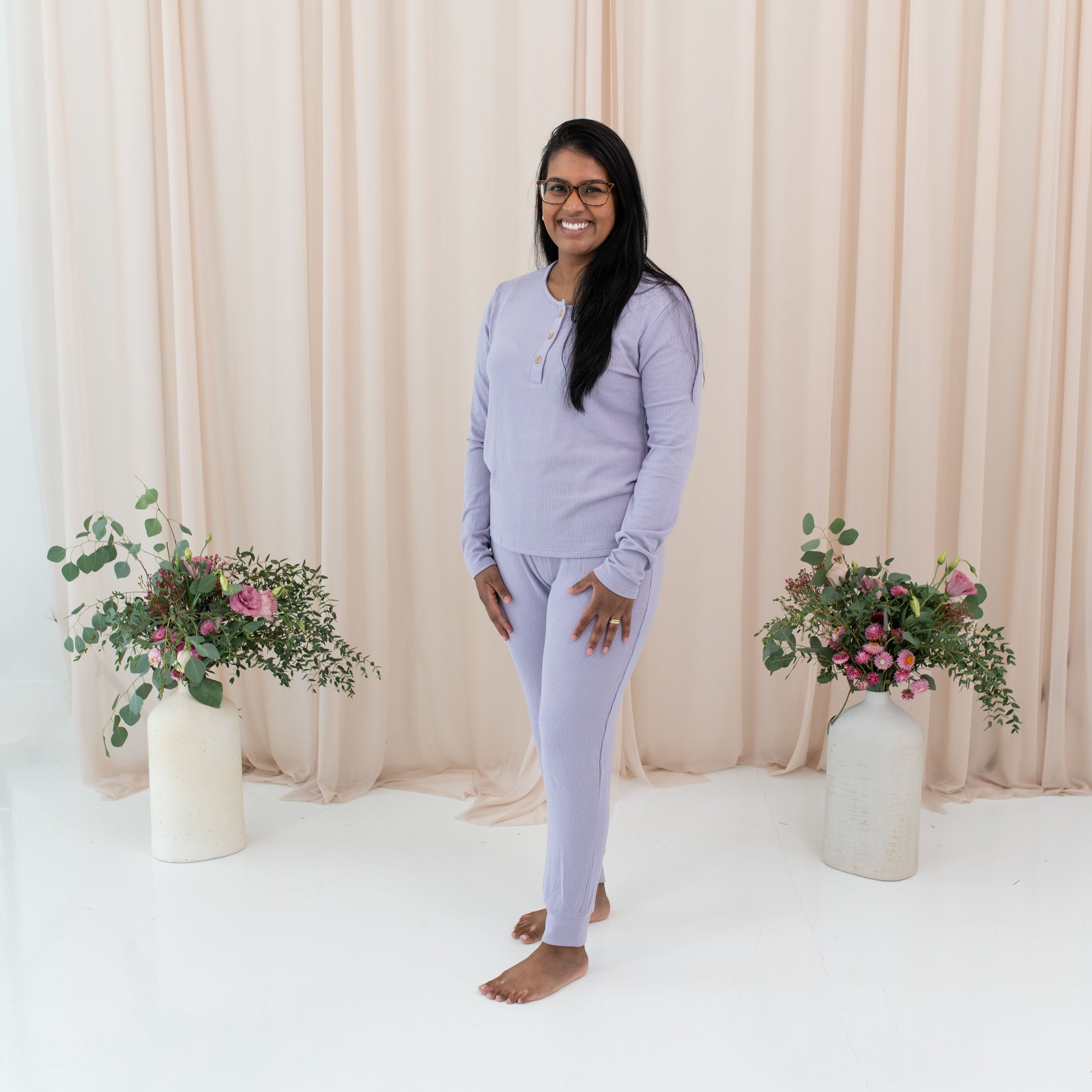 Woman wearing Kyte Baby Women's Ribbed Henley Top in Taro purple with matching jogger pants