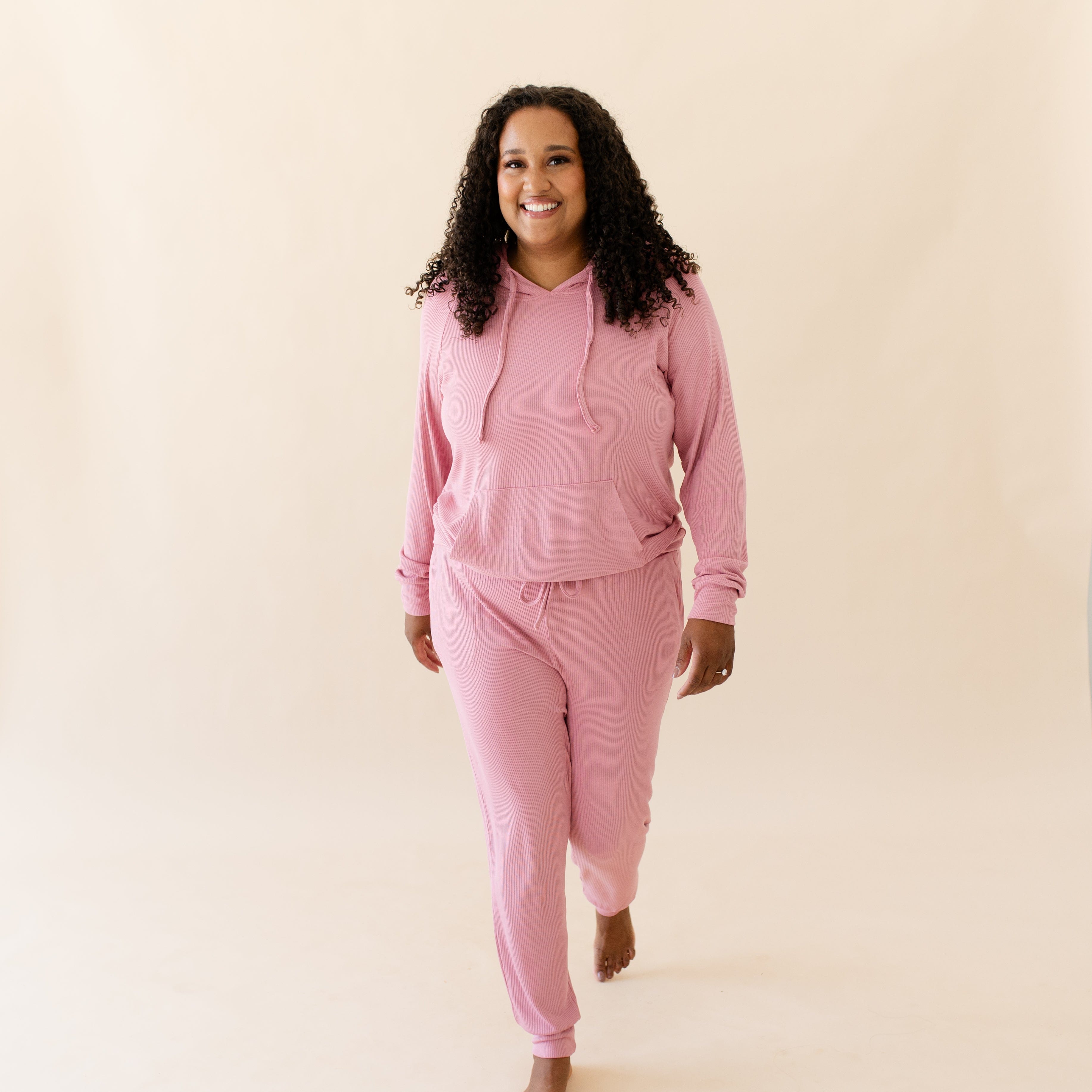Woman wearing Women's Ribbed Pink Hoodie in Apple Blossom with matching joggers