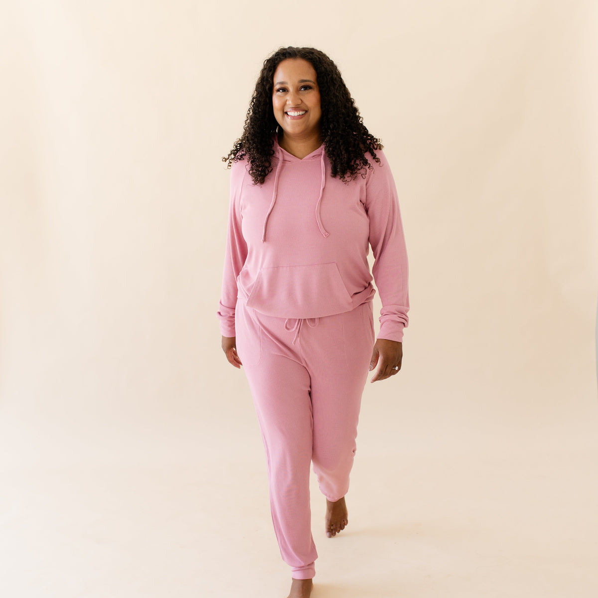 Woman wearing Women's Ribbed Pink Hoodie in Apple Blossom with matching joggers