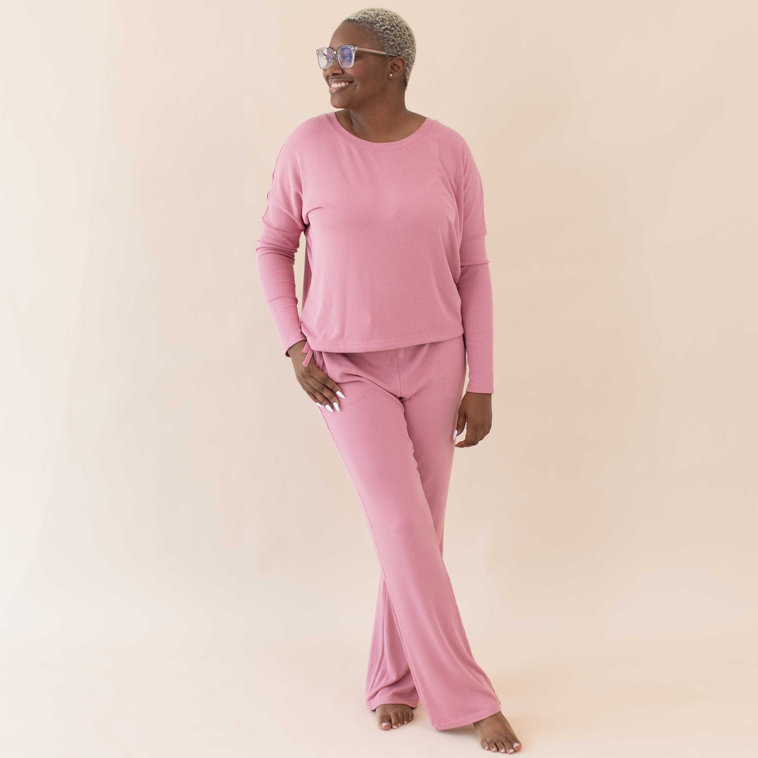 Woman wearing Kyte Baby Women's Ribbed Long Sleeve Top with Drop Shoulder in Apple Blossom pink