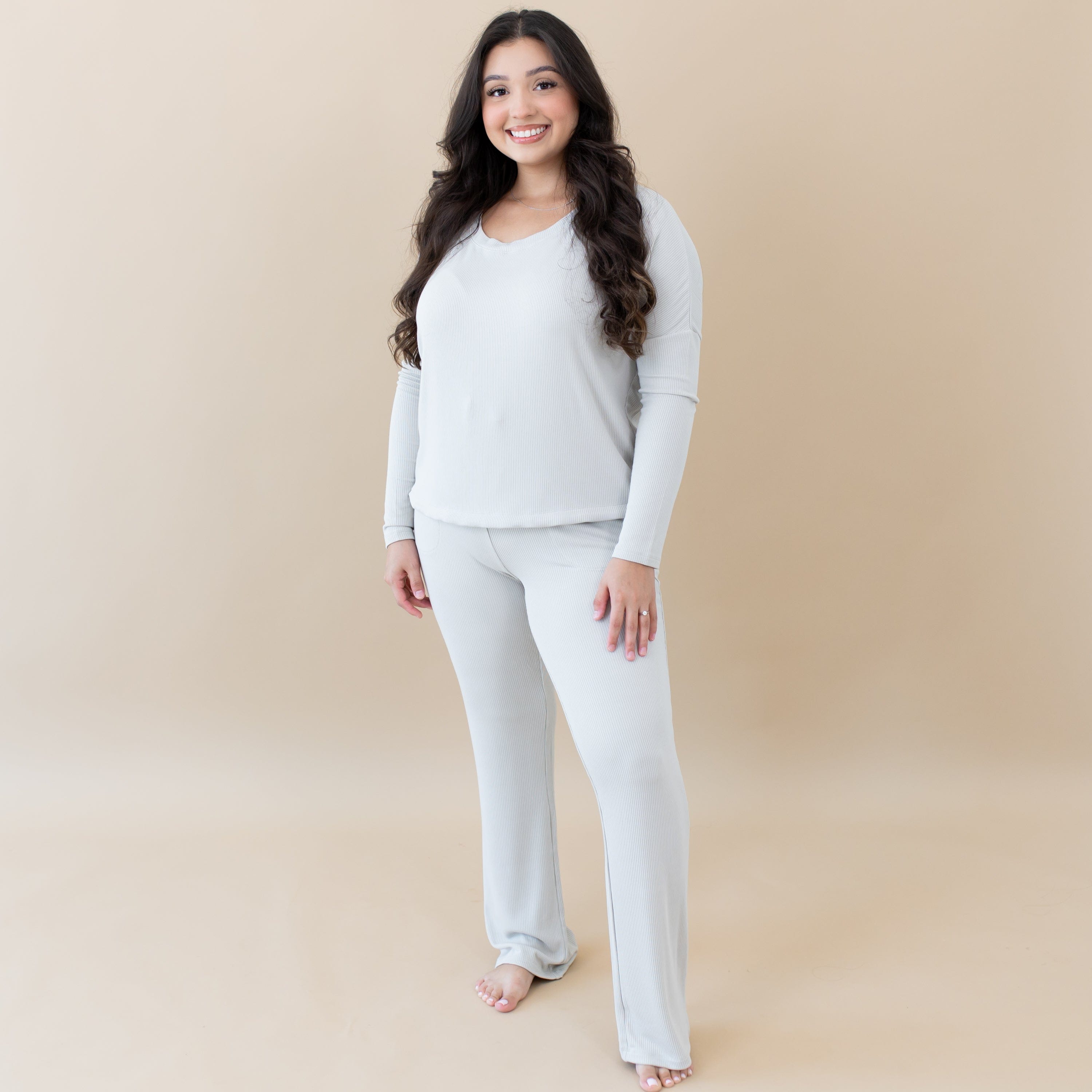 Woman wearing Kyte Baby Women's Ribbed Long Sleeve Drop Shoulder Top and Wide Leg Pant in Oat