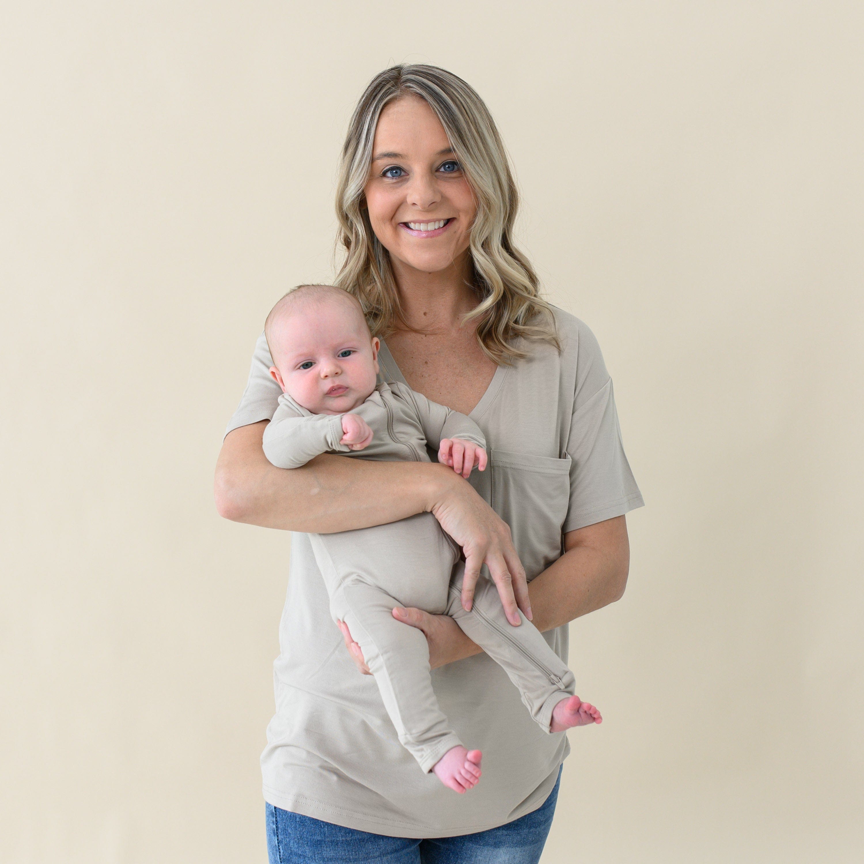 Mom wearing Women's Relaxed Fit V-Neck in Almond holding Infant in matching mommy and me outfit
