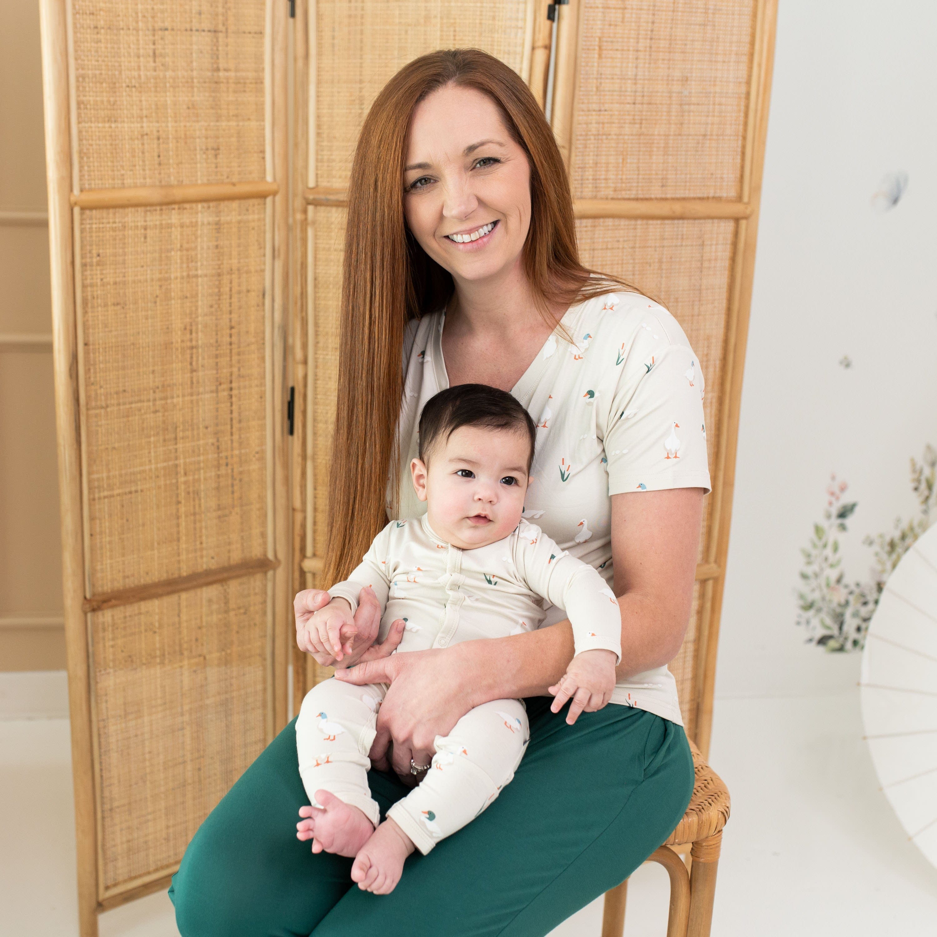 Woman wearing Kyte Baby Women's Relaxed Fit V-Neck in Duck holding infant wearing matching romper