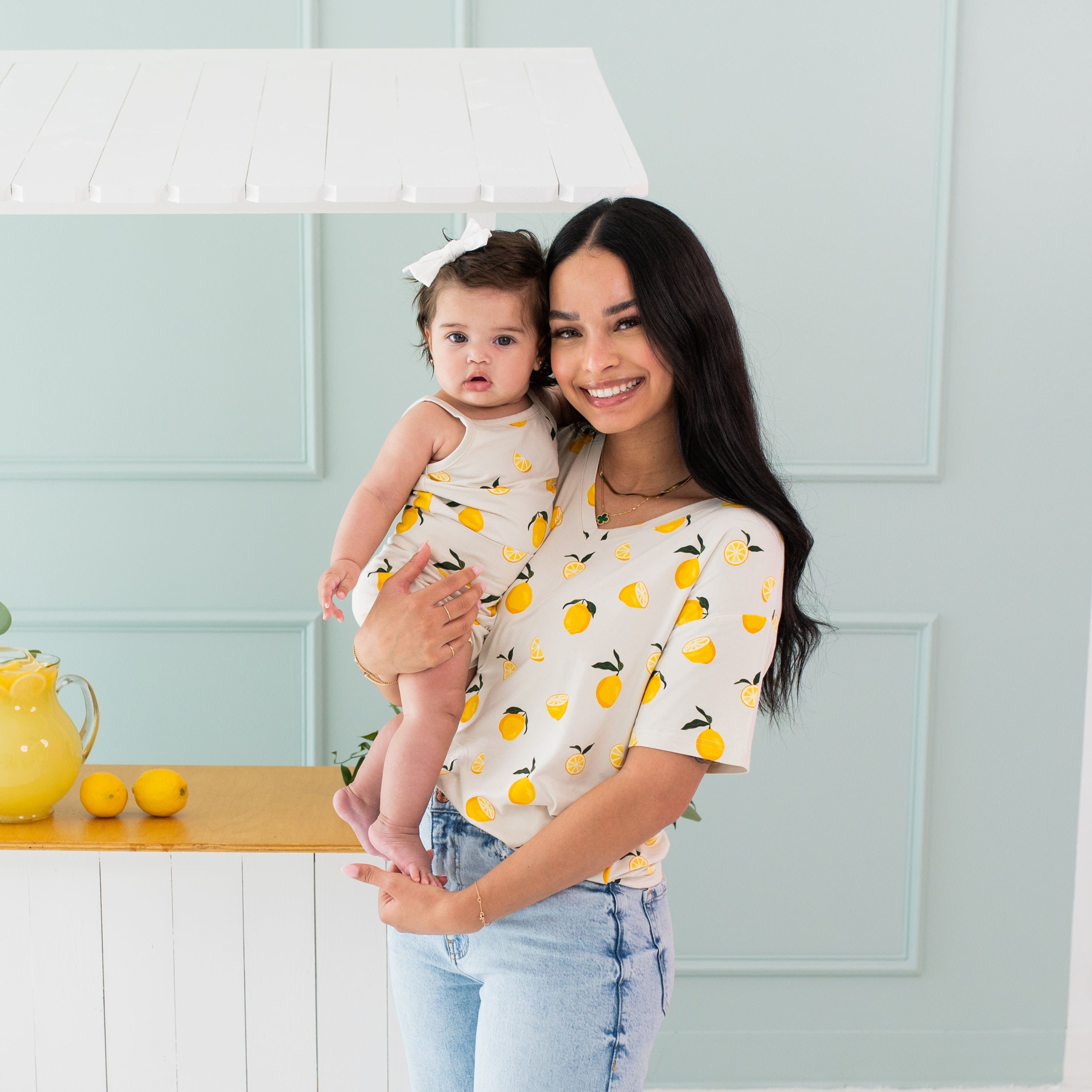 Woman wearing Kyte Baby Women's Relaxed Fit V-Neck in Lemon with infant in matching outfit
