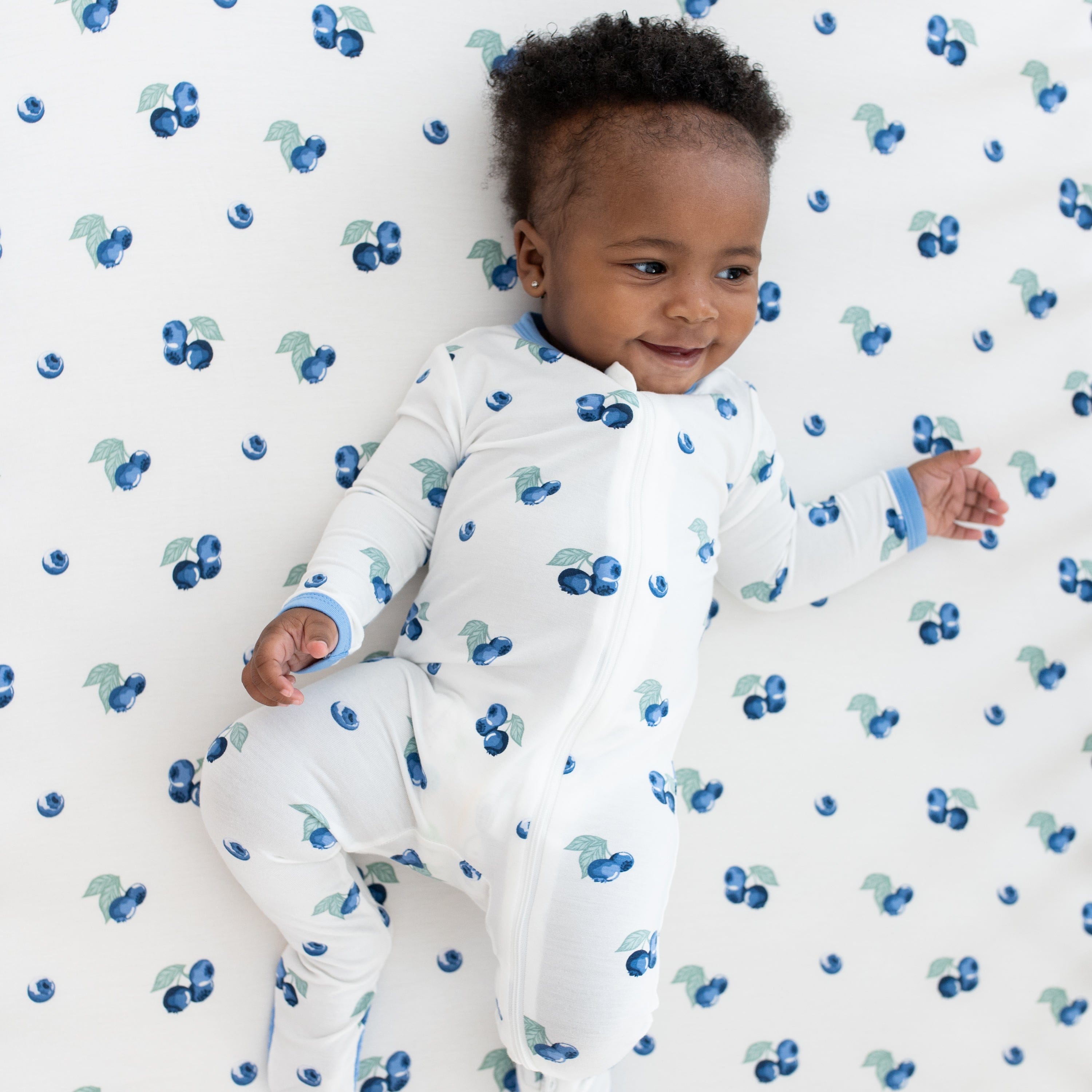 Infant wearing Kyte Baby Zippered Footie in Blueberry