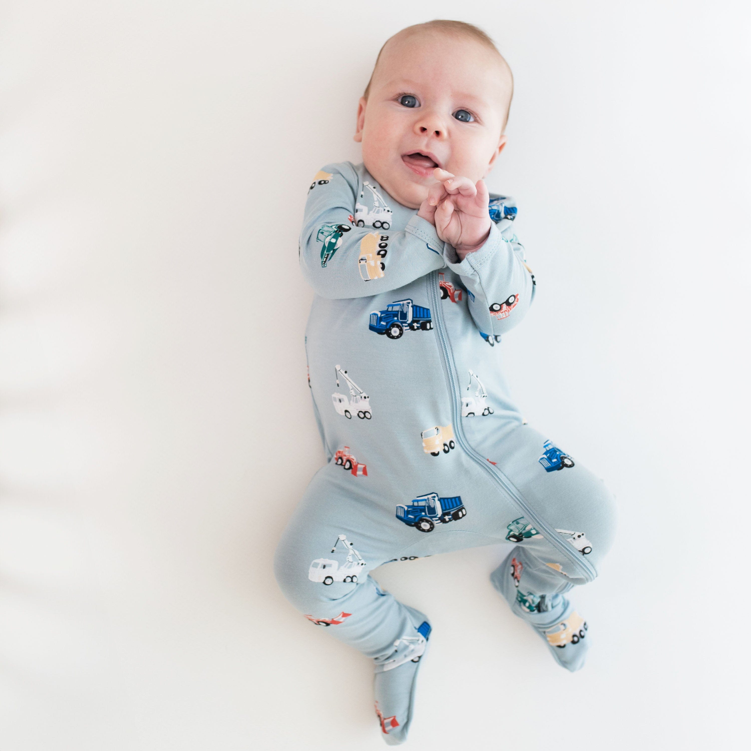 Infant wearing Kyte Baby Zippered Footie in Construction