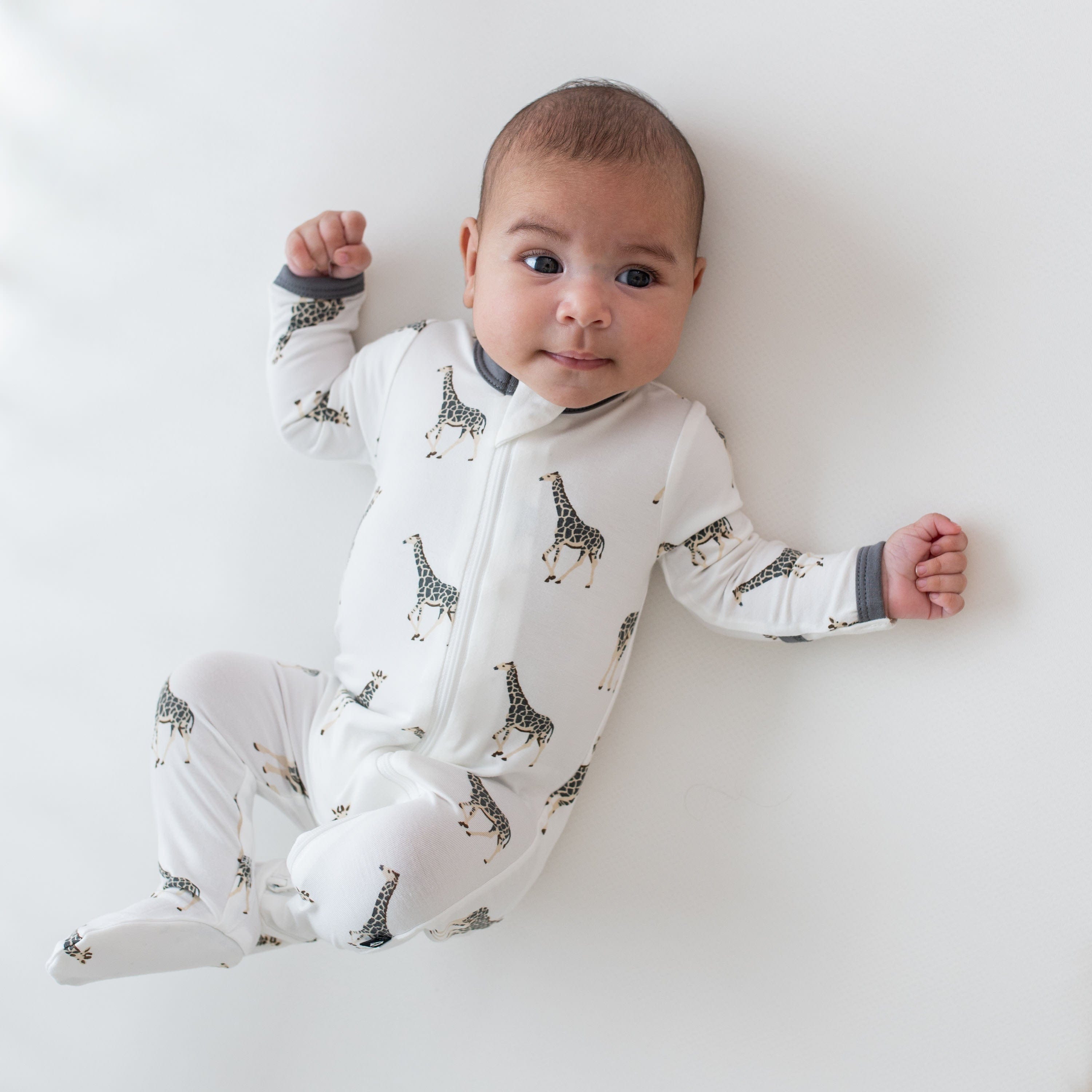 Baby wearing Kyte Baby Zippered Footie in Giraffe