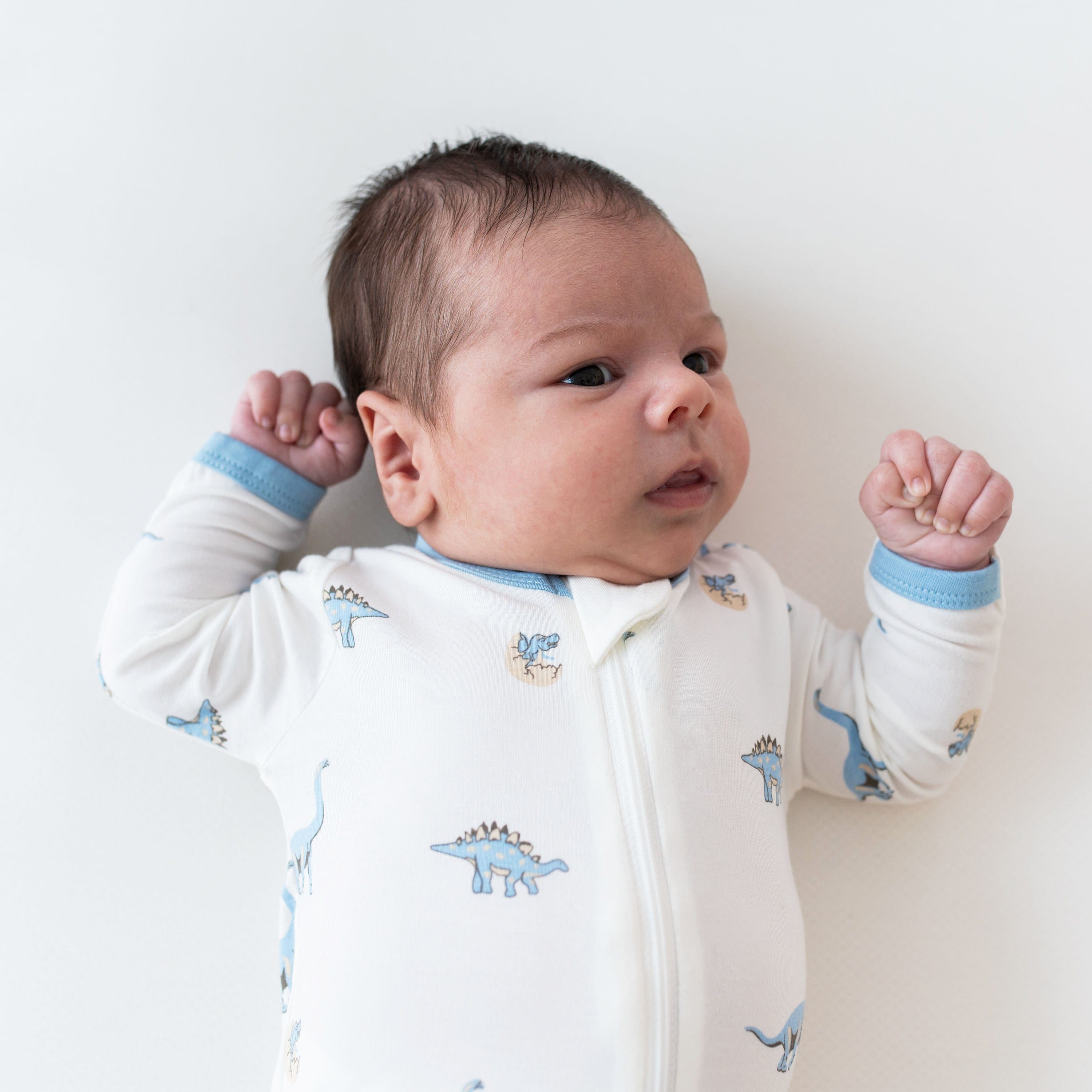 Newborn wearing Kyte Baby breathable bamboo Zippered Footie in Jurassic