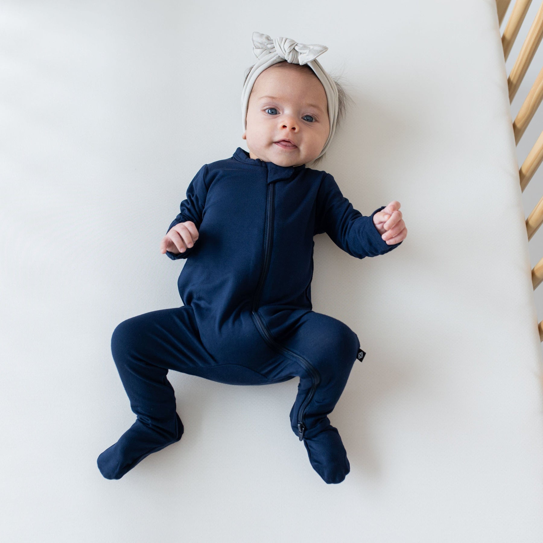 Baby wearing Kyte Baby breathable bamboo Zippered Footie in Navy