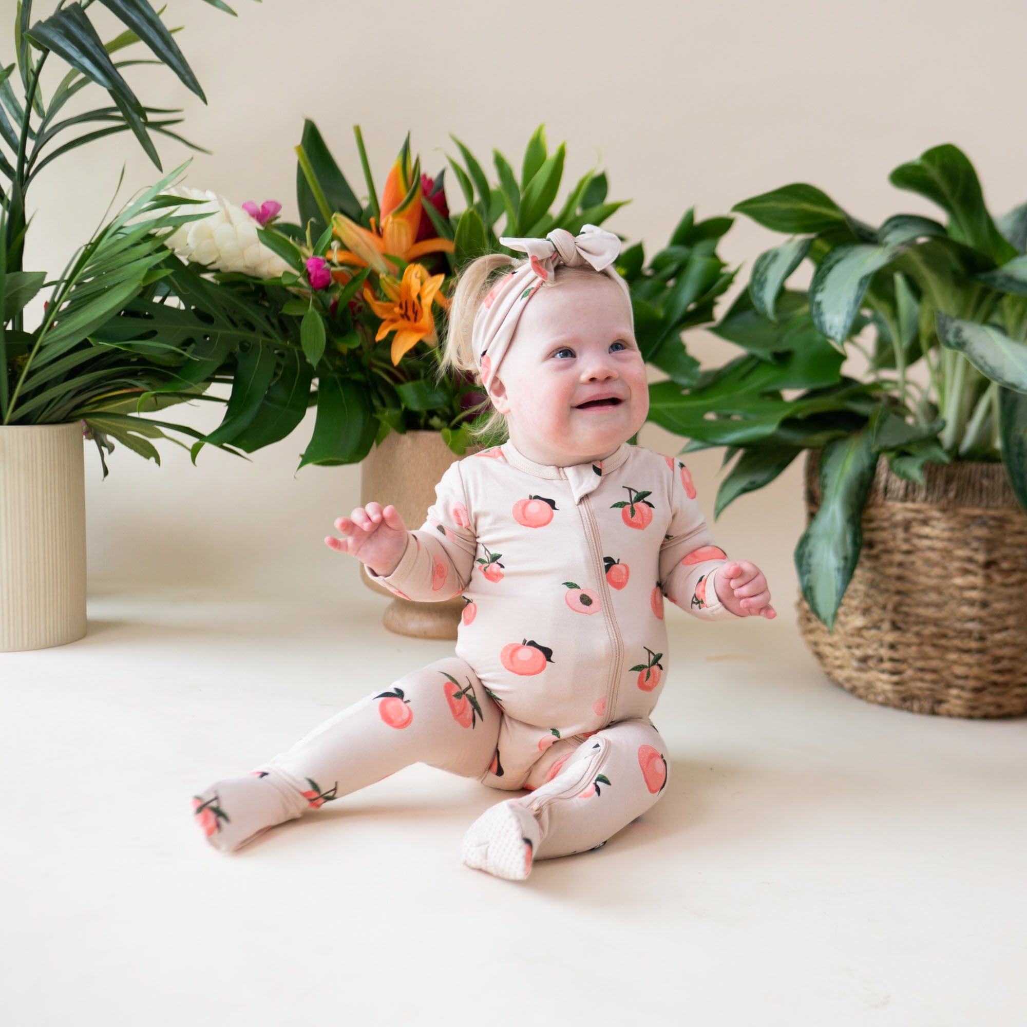 Baby wearing Kyte Baby breathable bamboo Zippered Footie in Peach