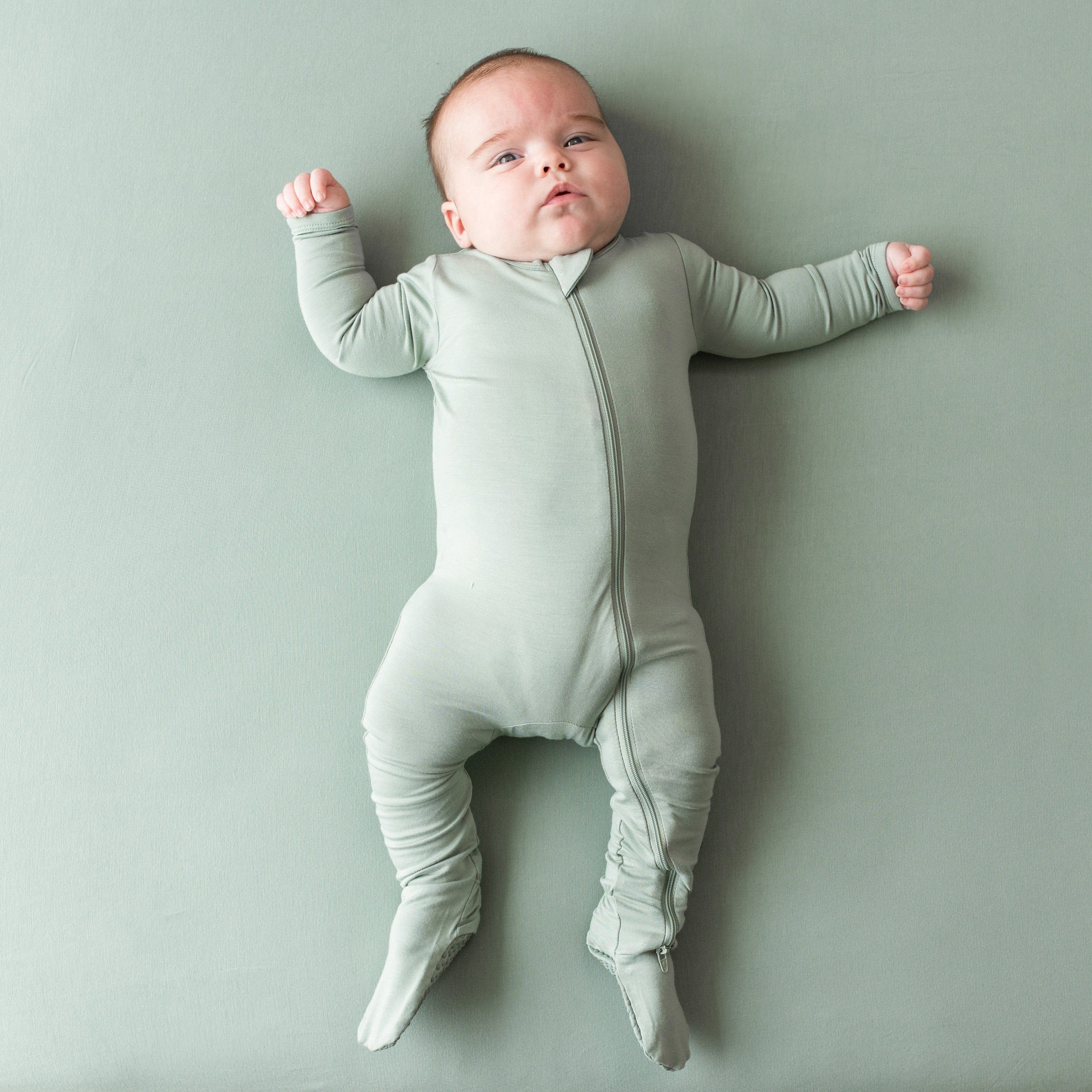 Infant wearing Zippered Footie kids pajamas in Thyme
