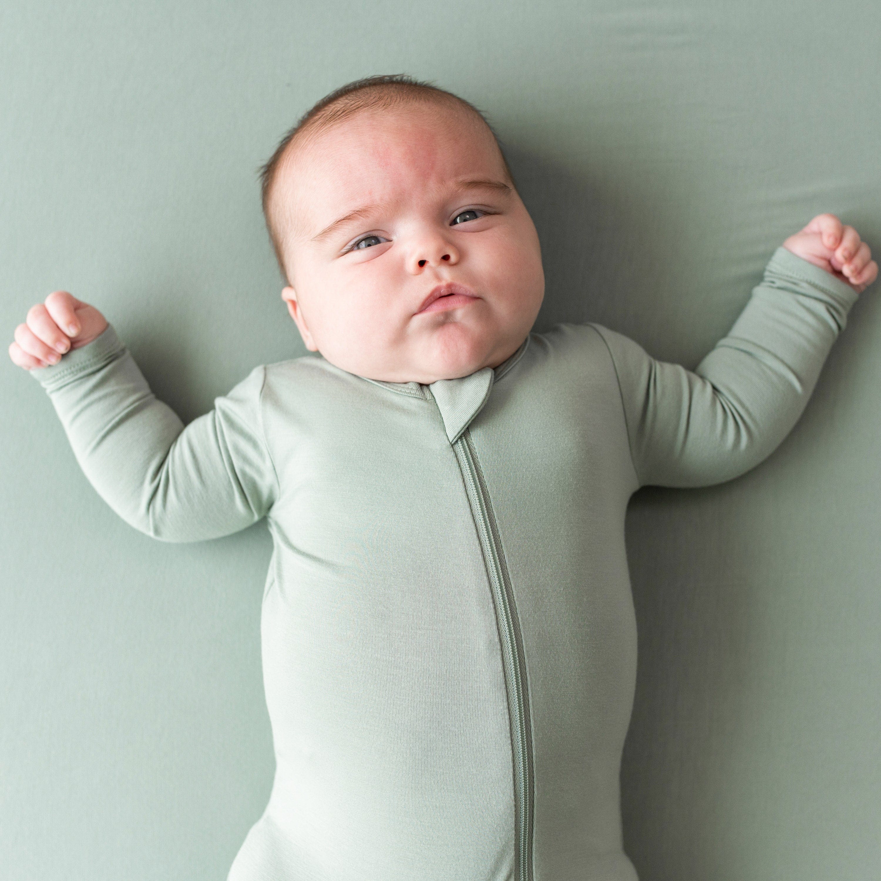 Infant wearing Zippered bamboo Footie in Thyme green