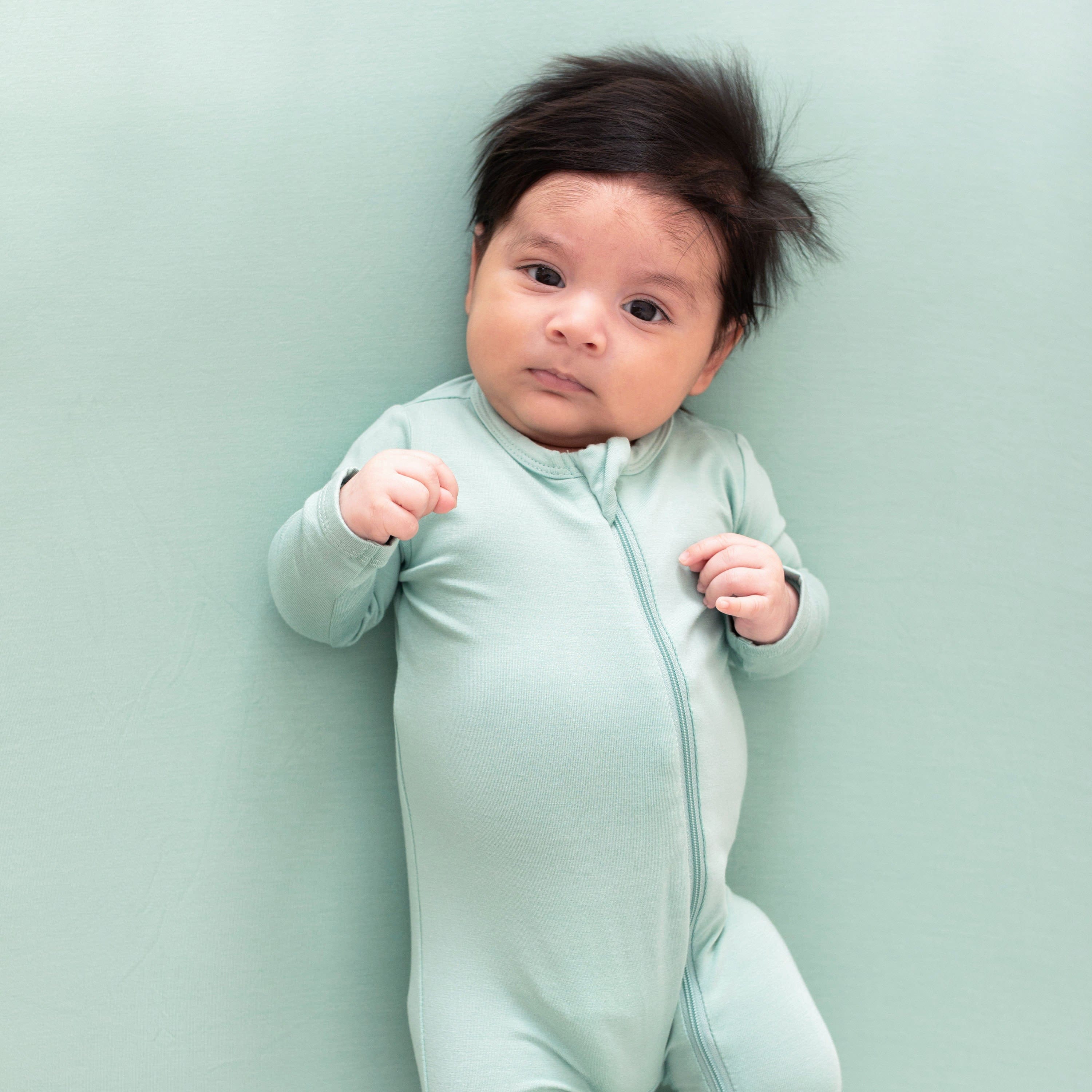 Infant wearing Kyte Baby Zippered Footie in Wasabi