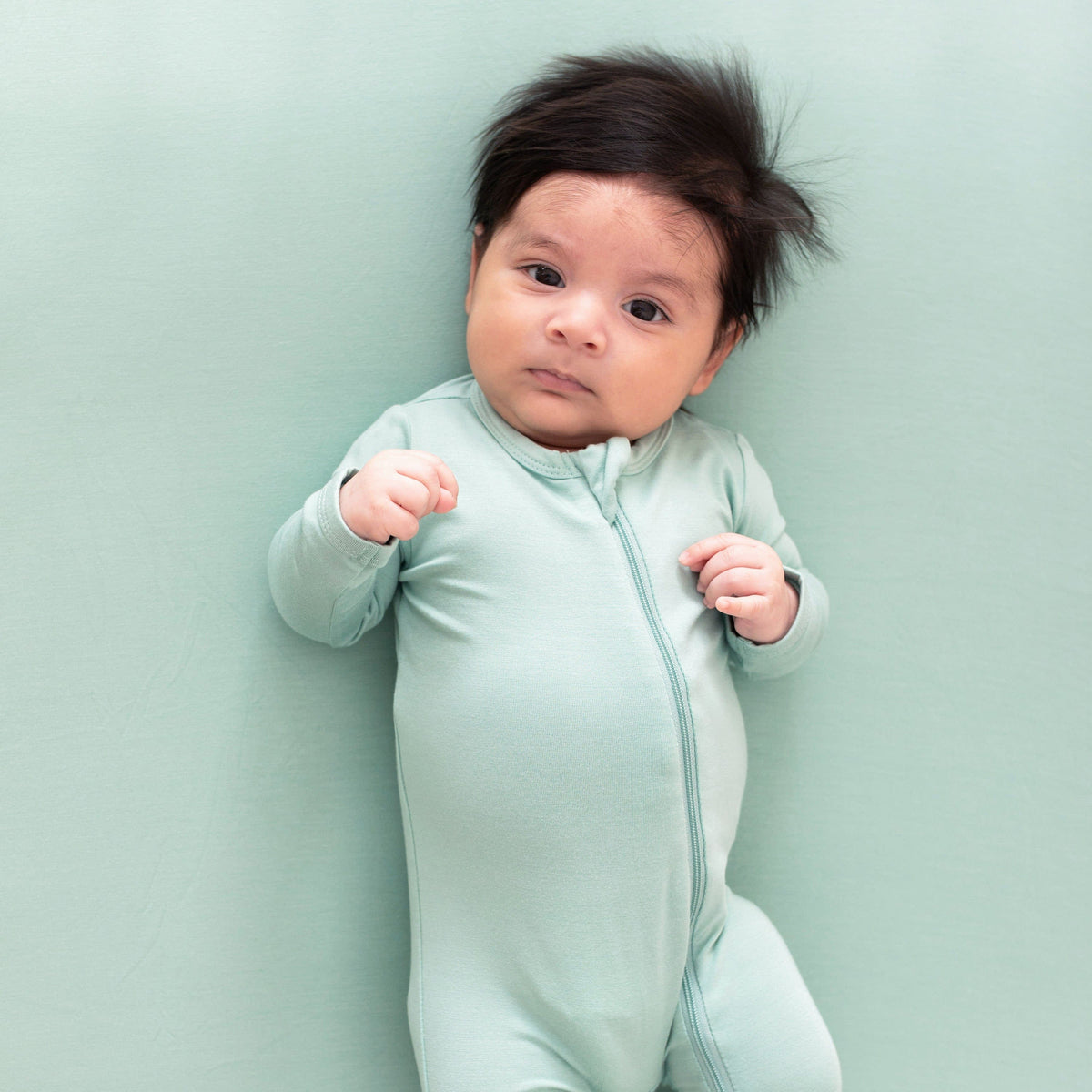 Infant wearing Kyte Baby Zippered Footie in Wasabi