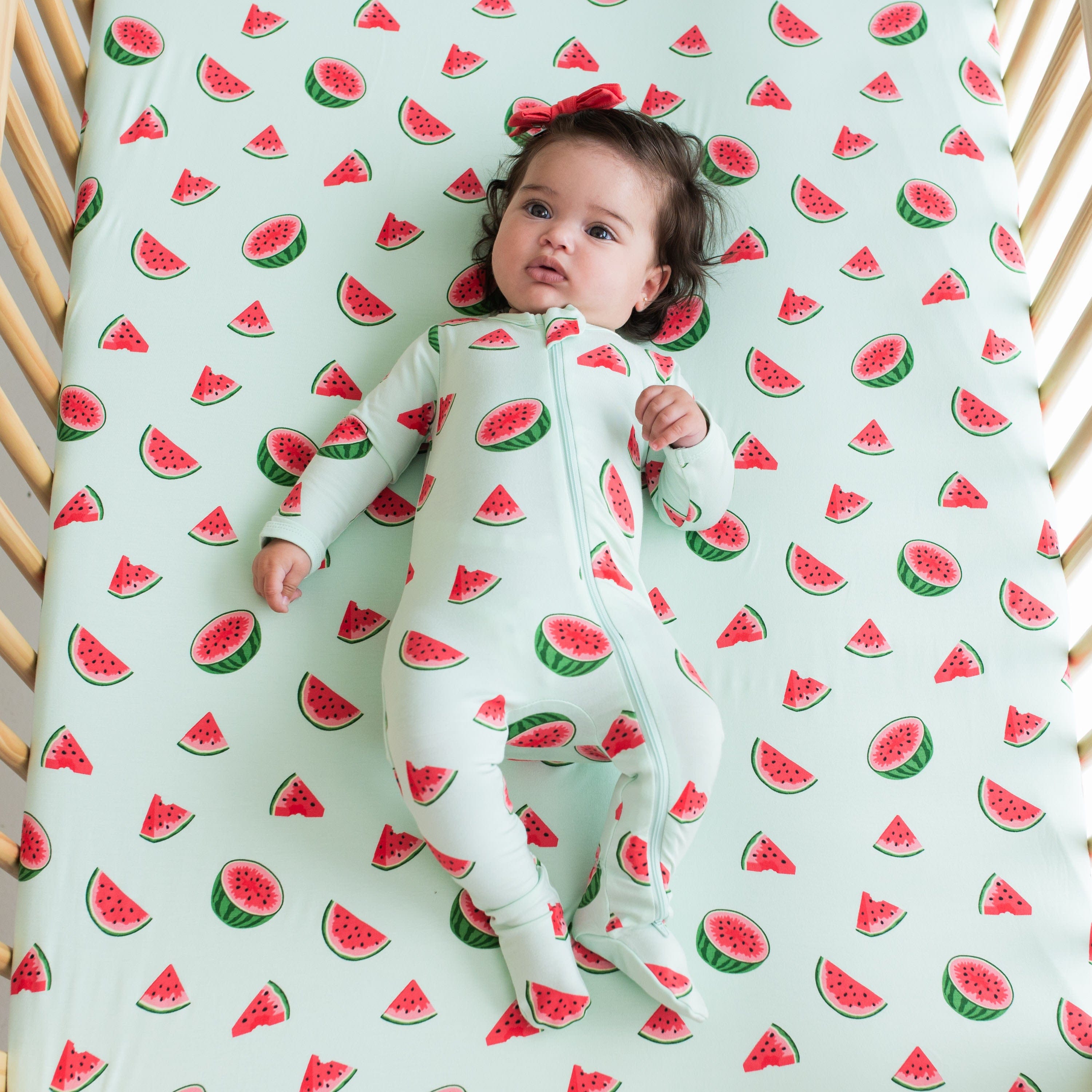 Infant wearing the Zippered Footie kids pajamas in Watermelon fruit print