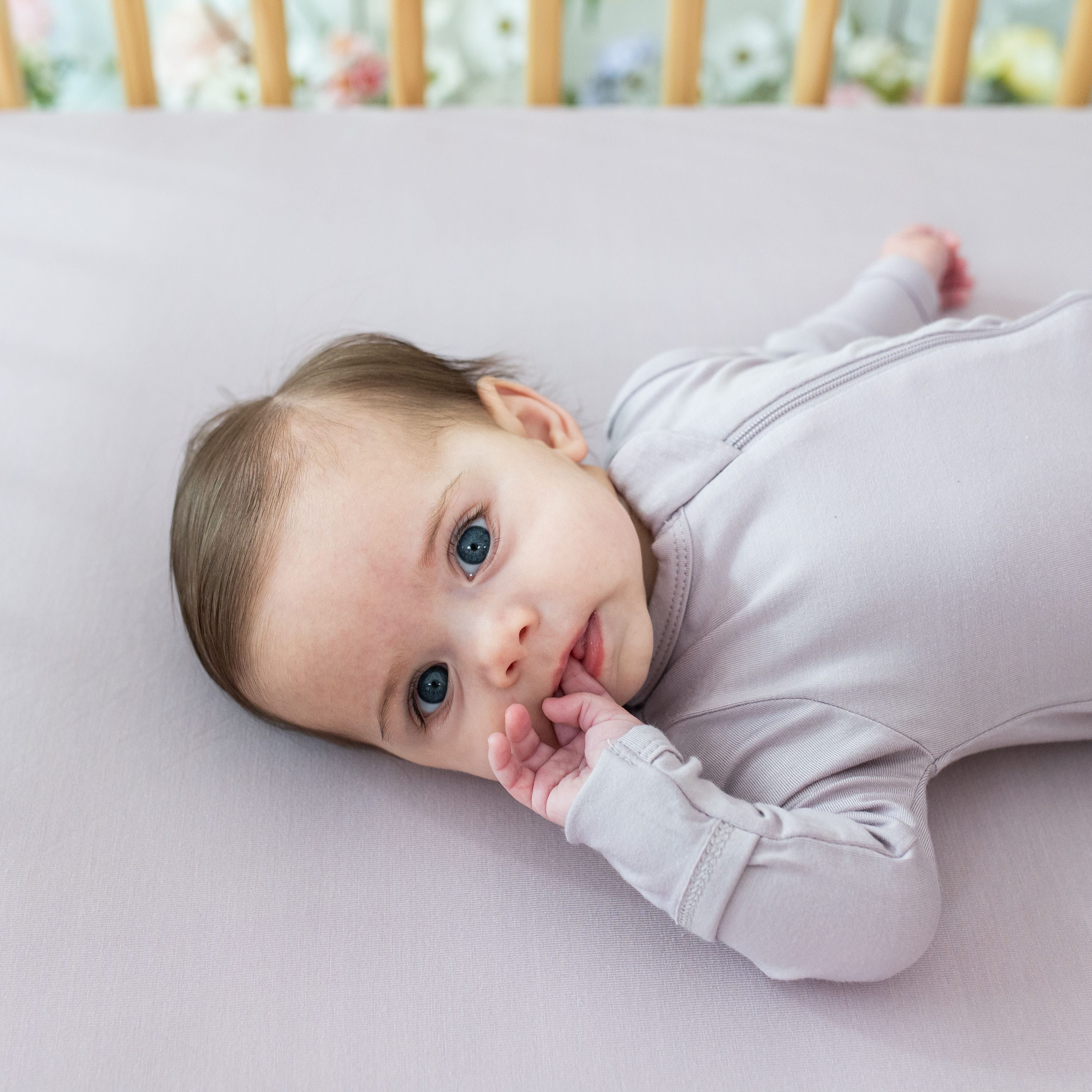 Baby wearing Kyte Baby breathable bamboo Zippered Footie in Wisteria