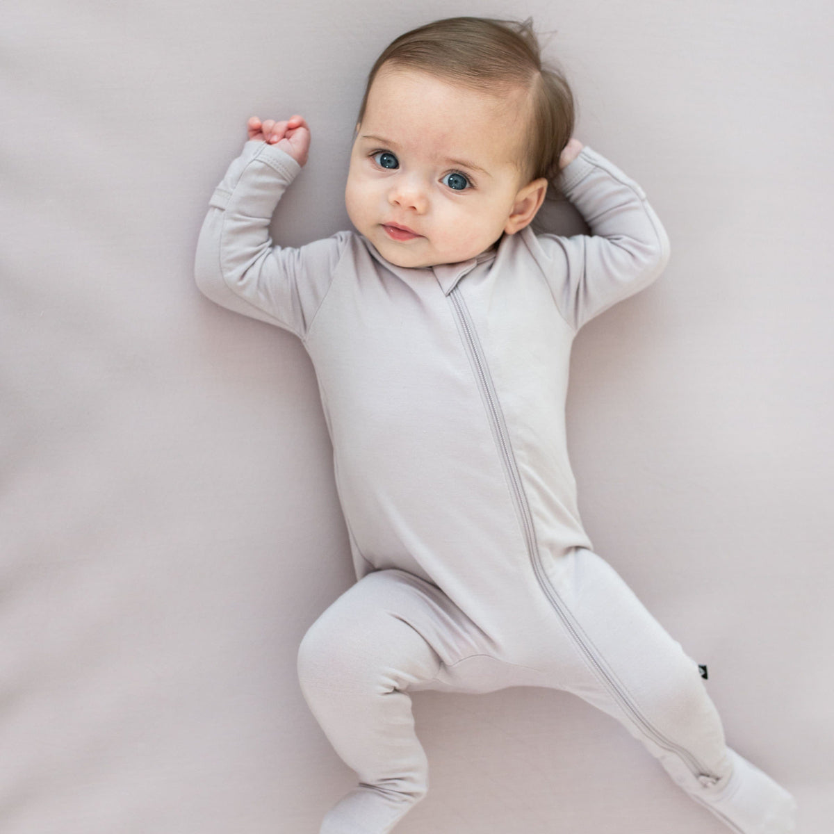 Infant wearing Kyte Baby Zippered Footie in Wisteria