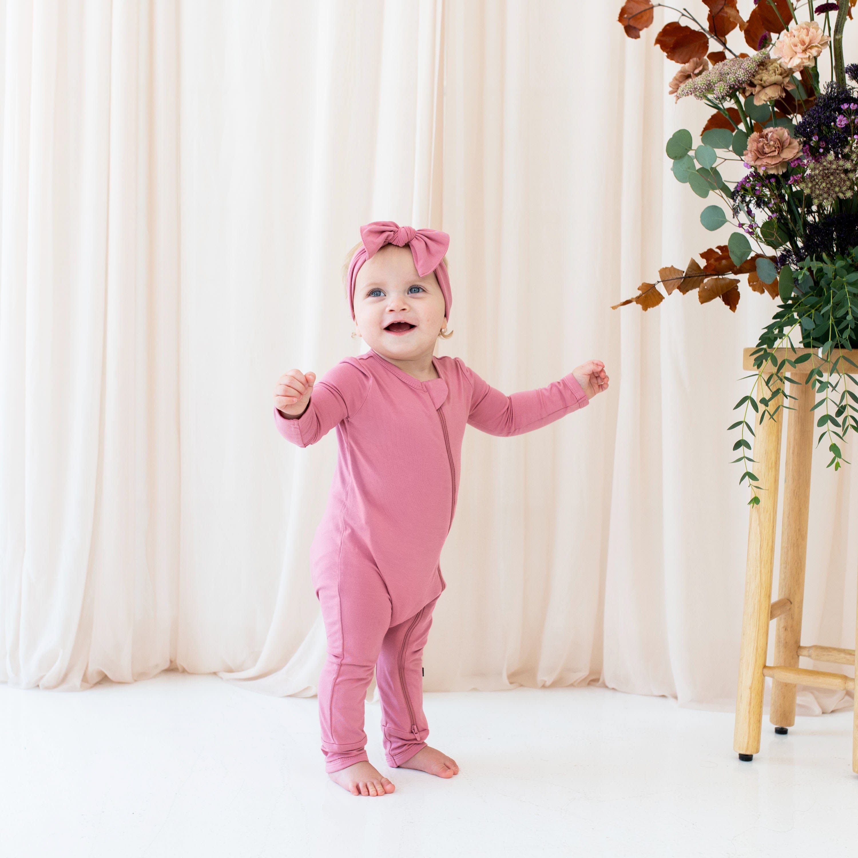 Child wearing Zippered Romper in Apple Blossom pink