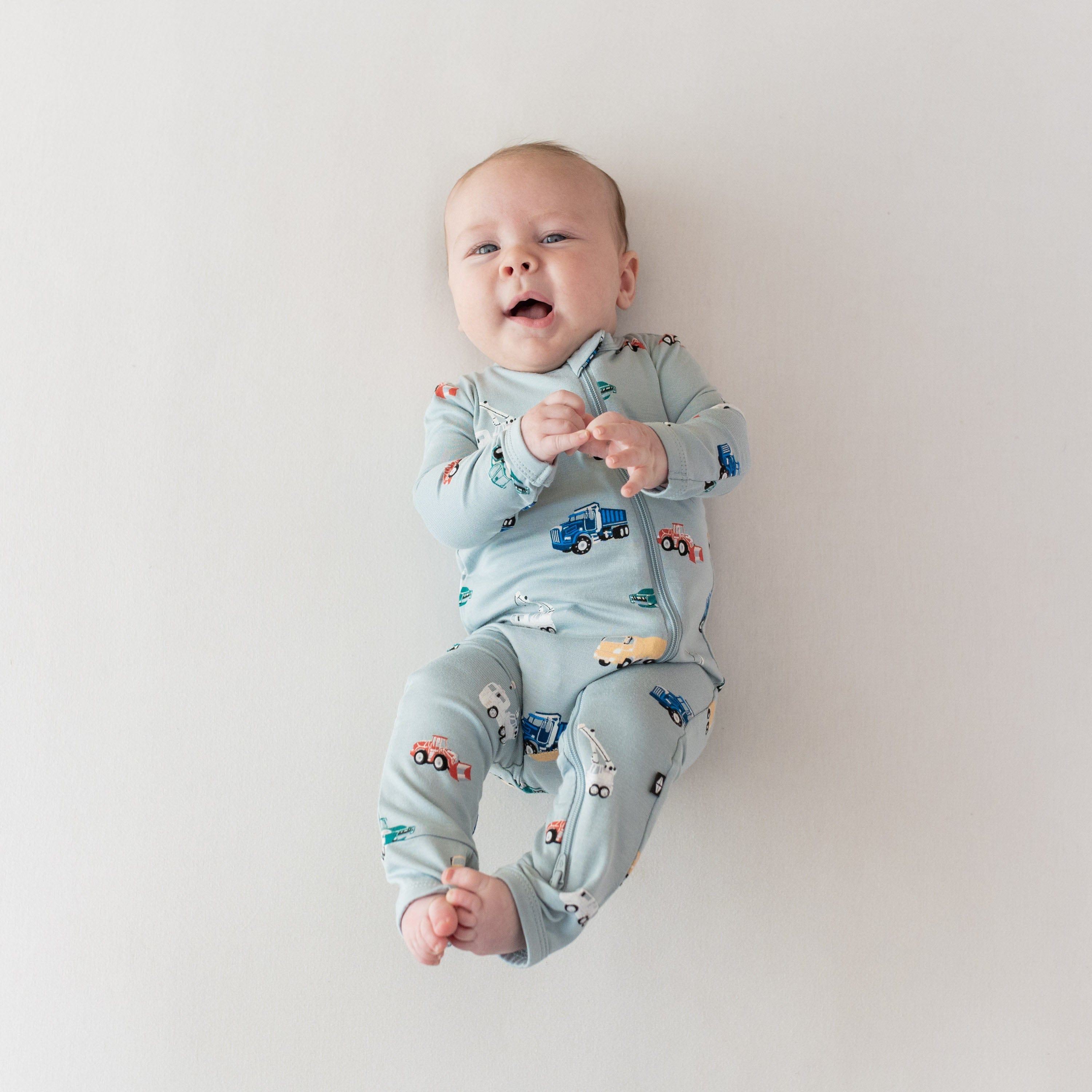 Baby wearing Kyte Baby Zippered Romper in Construction