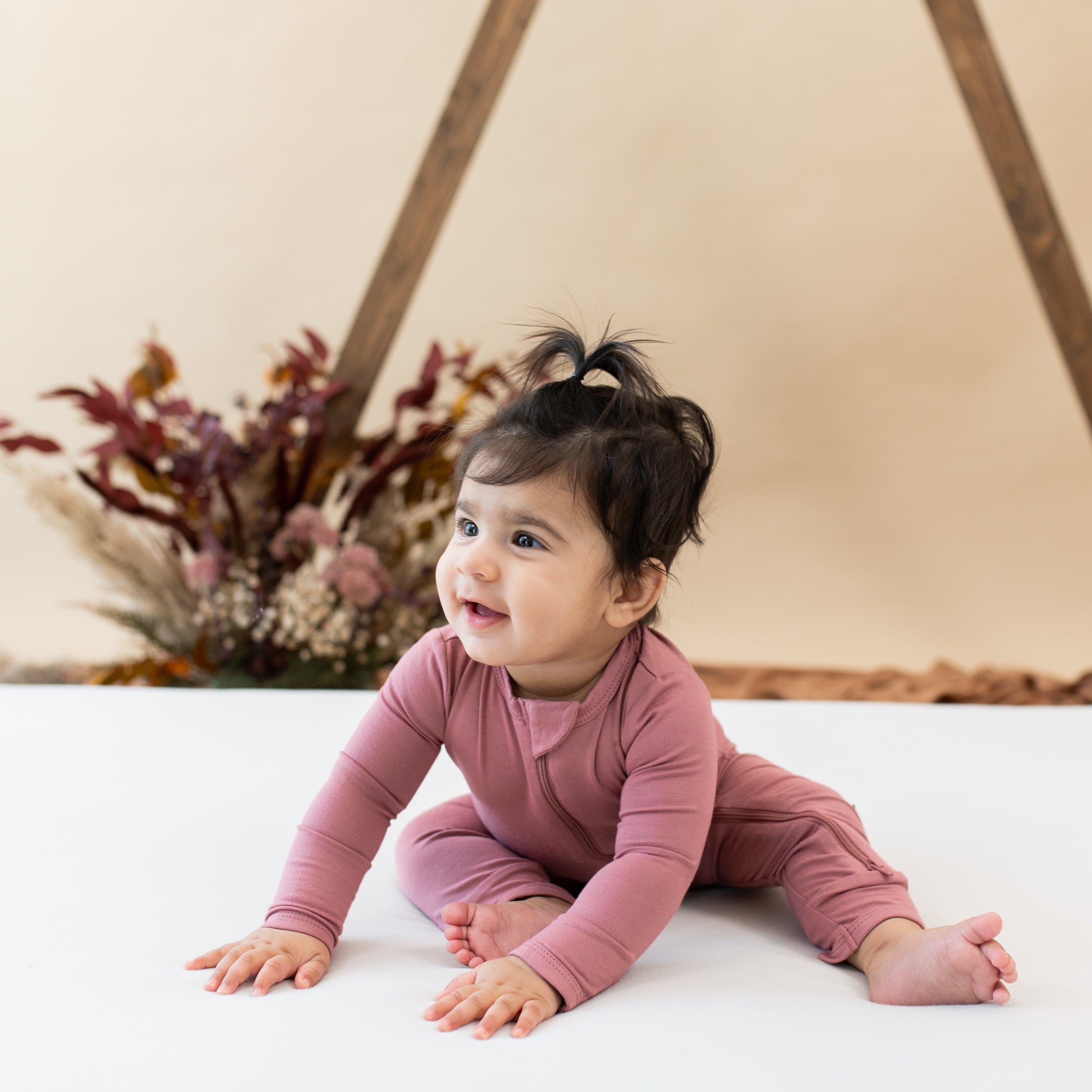 Baby wearing Kyte Baby Zippered Romper in Dusty Rose