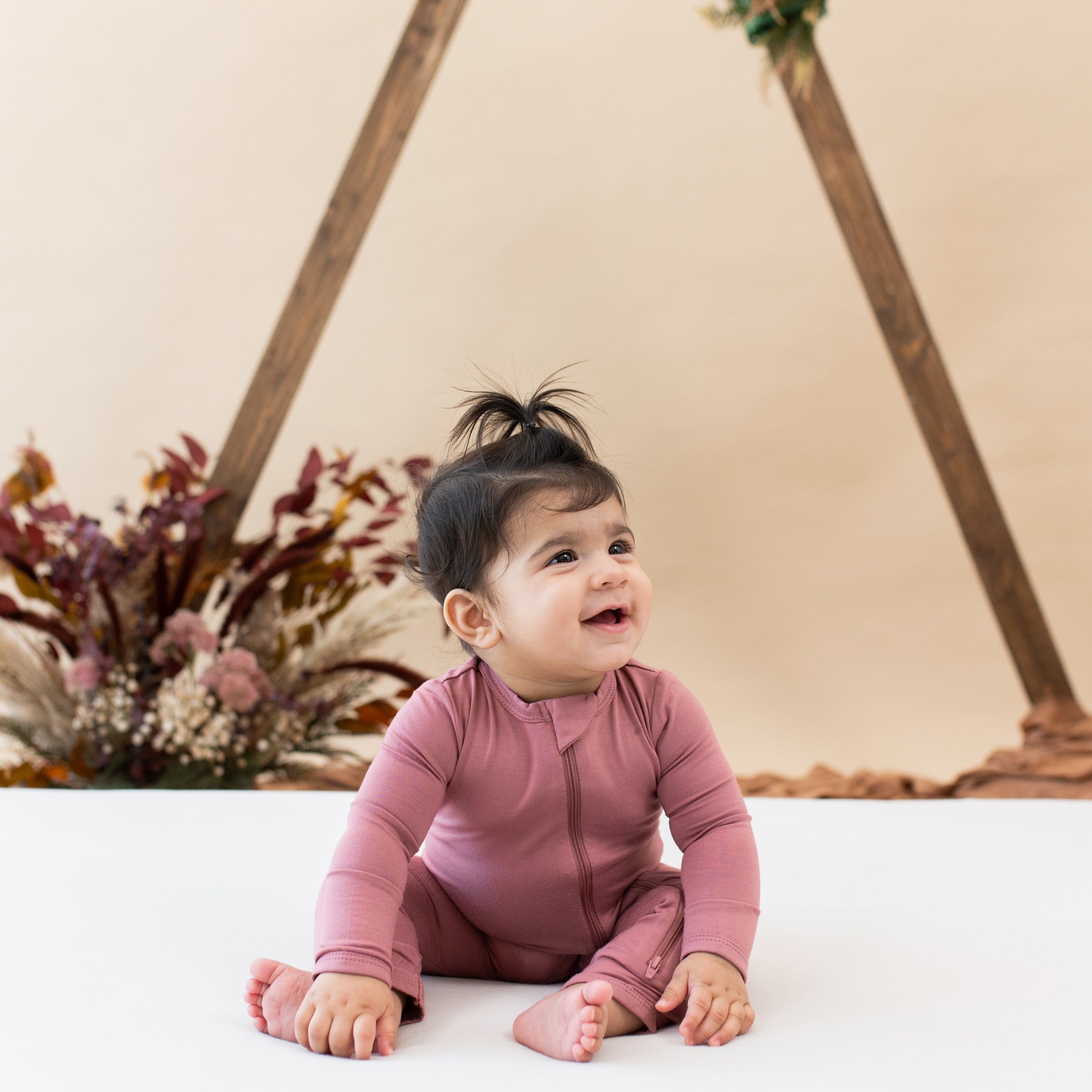 Infant wearing Kyte Baby Zippered Romper in Dusty Rose