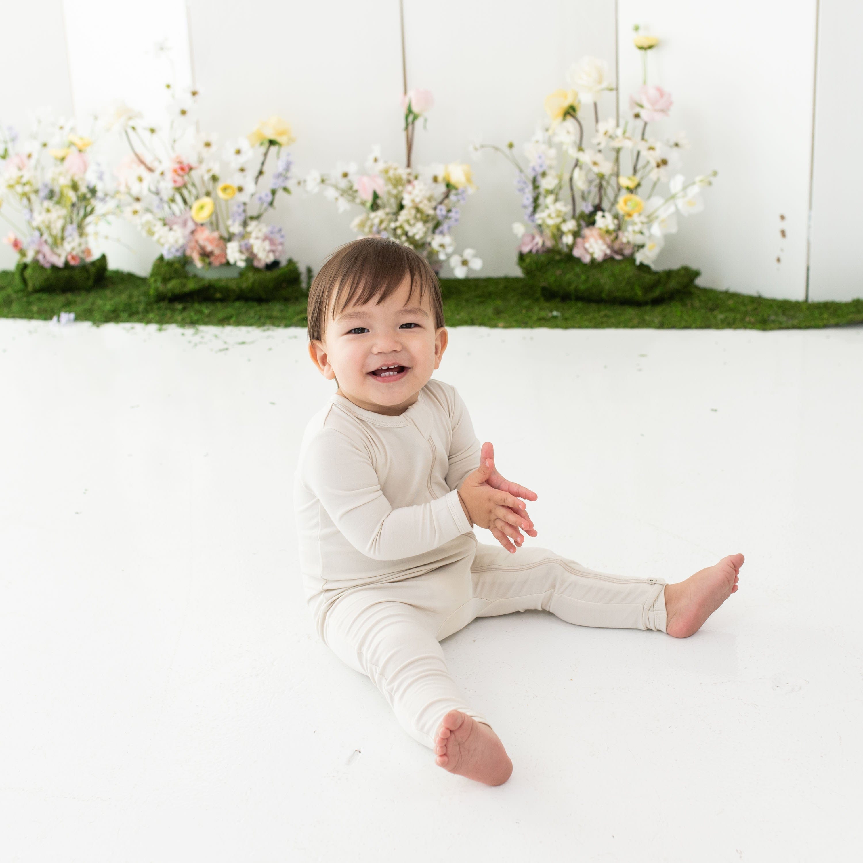 Toddler wearing Kyte Baby Zippered Romper pajamas in Ecru